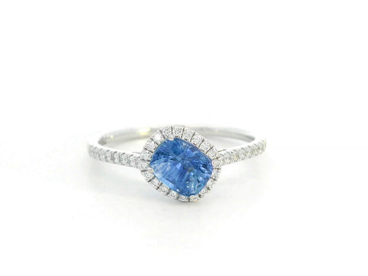 Ring with a blue gemstone and diamond accents on a white background