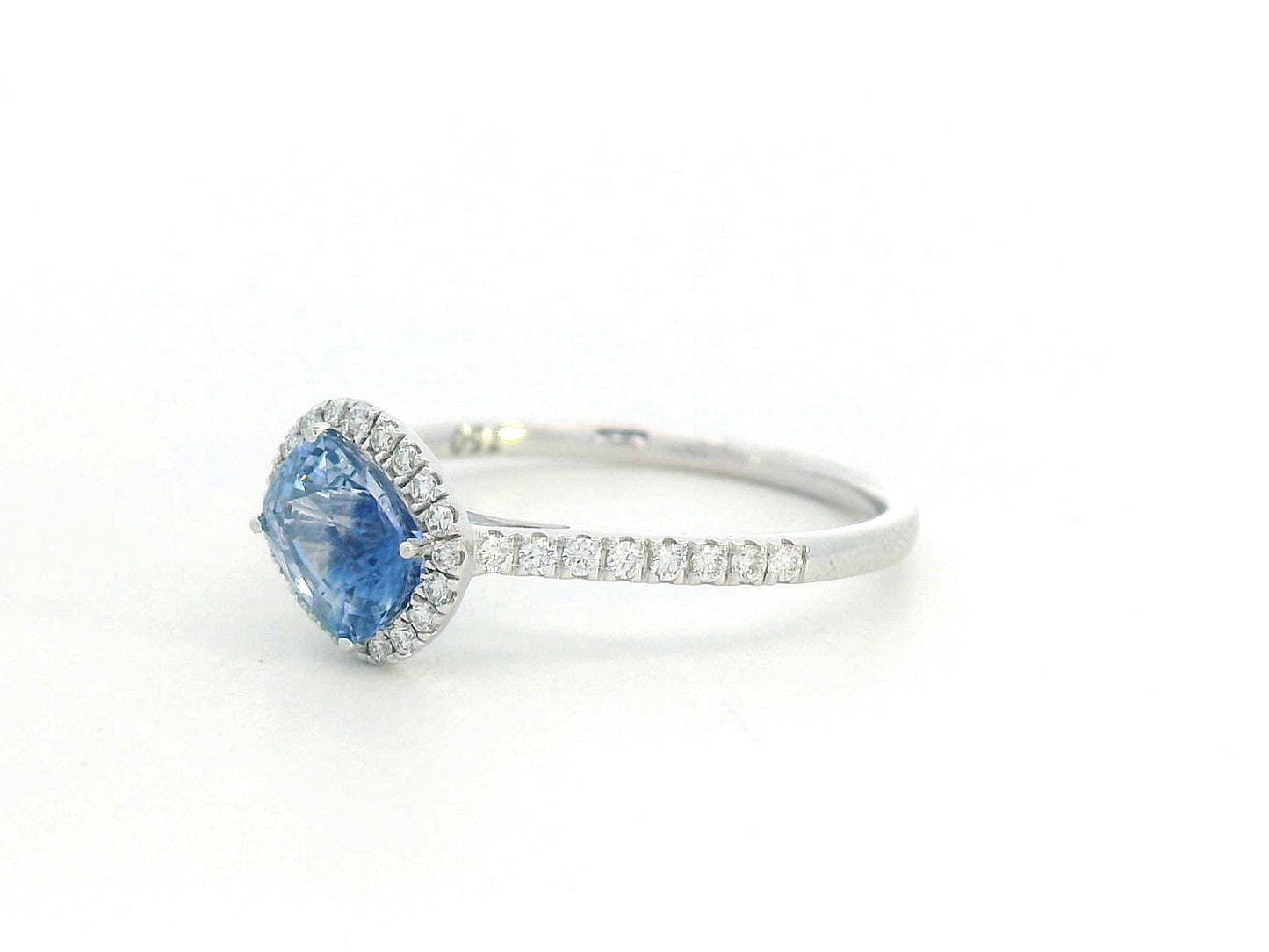 Ring with a blue gemstone and diamond accents on a white background