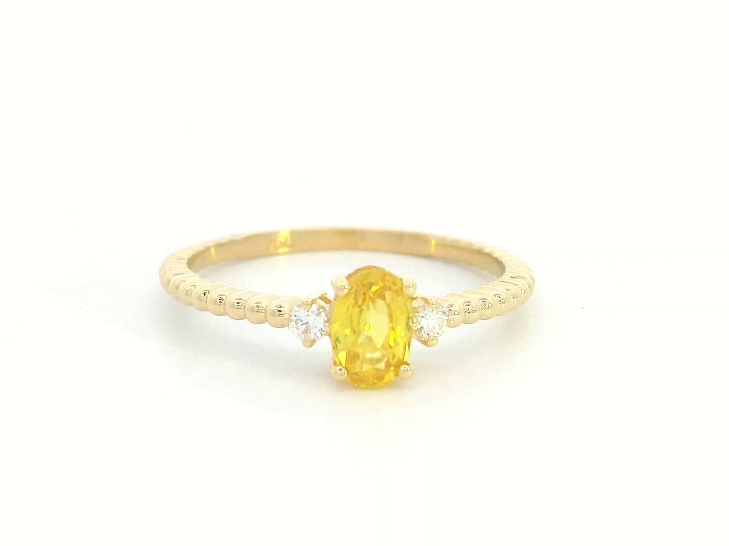 18K gold ring with oval yellow sapphire, side diamonds, and textured beaded band