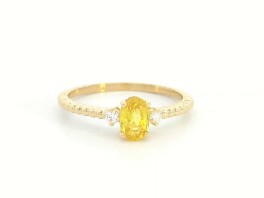 18K gold ring with oval yellow sapphire, side diamonds, and textured beaded band