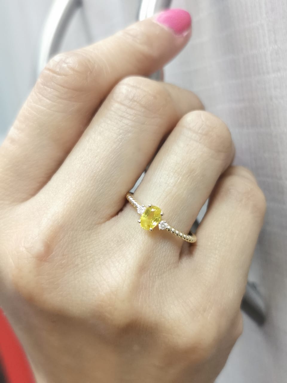 18K gold ring with oval yellow sapphire, side diamonds, and textured beaded band