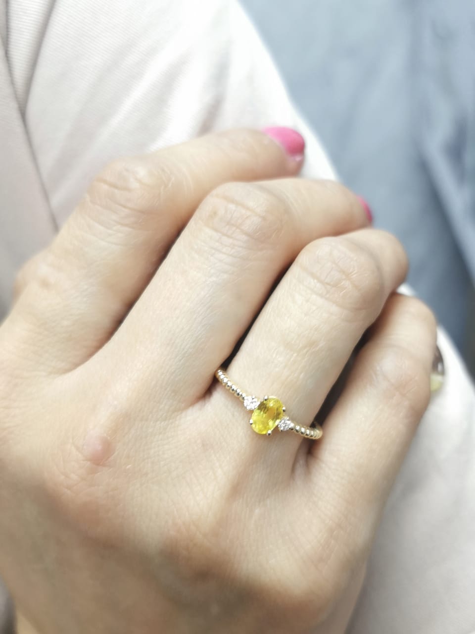 18K gold ring with oval yellow sapphire, side diamonds, and textured beaded band