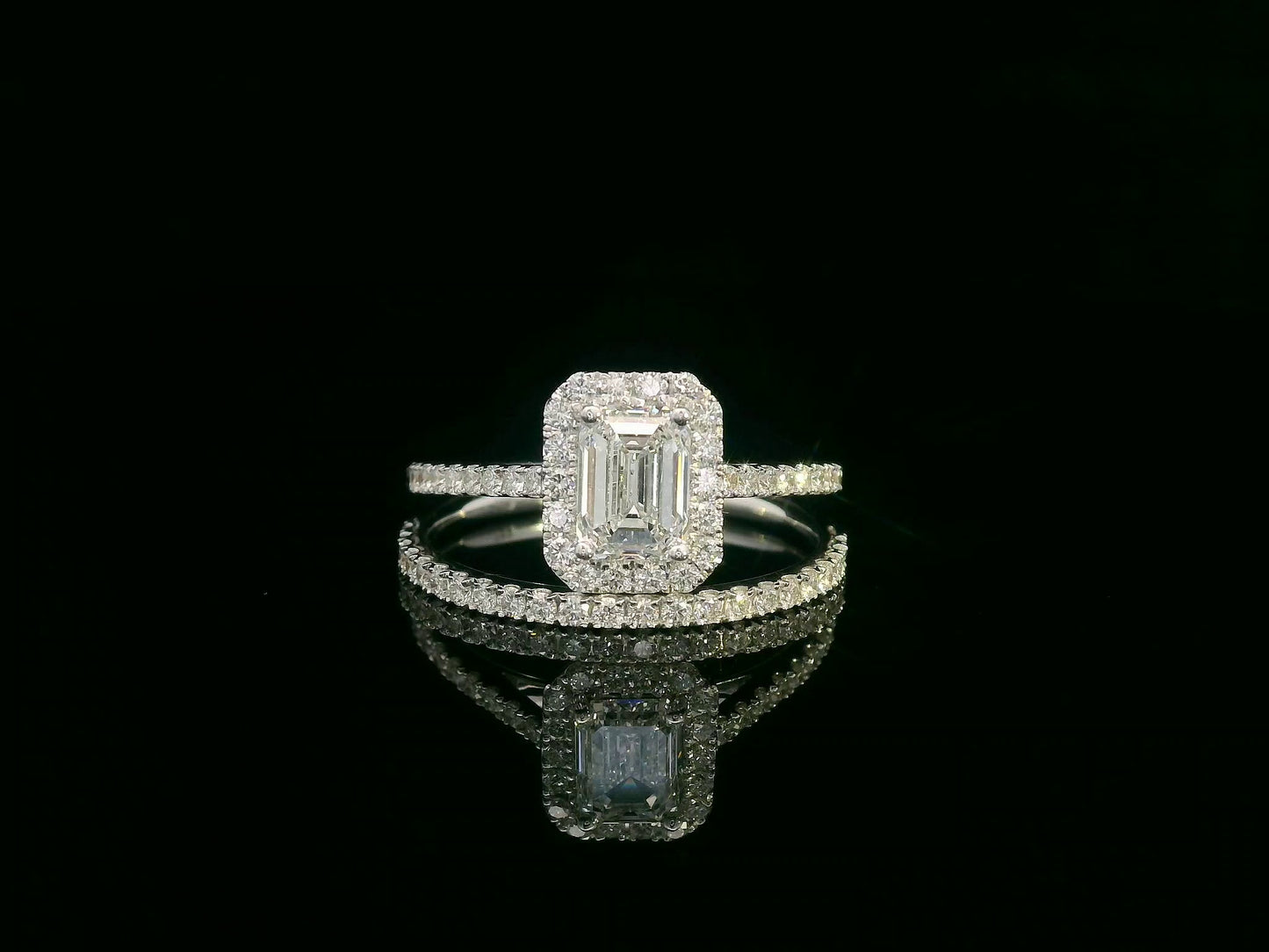 18K white gold bridal set with emerald-cut 1.00ct diamond, halo engagement ring, and half-eternity diamond band