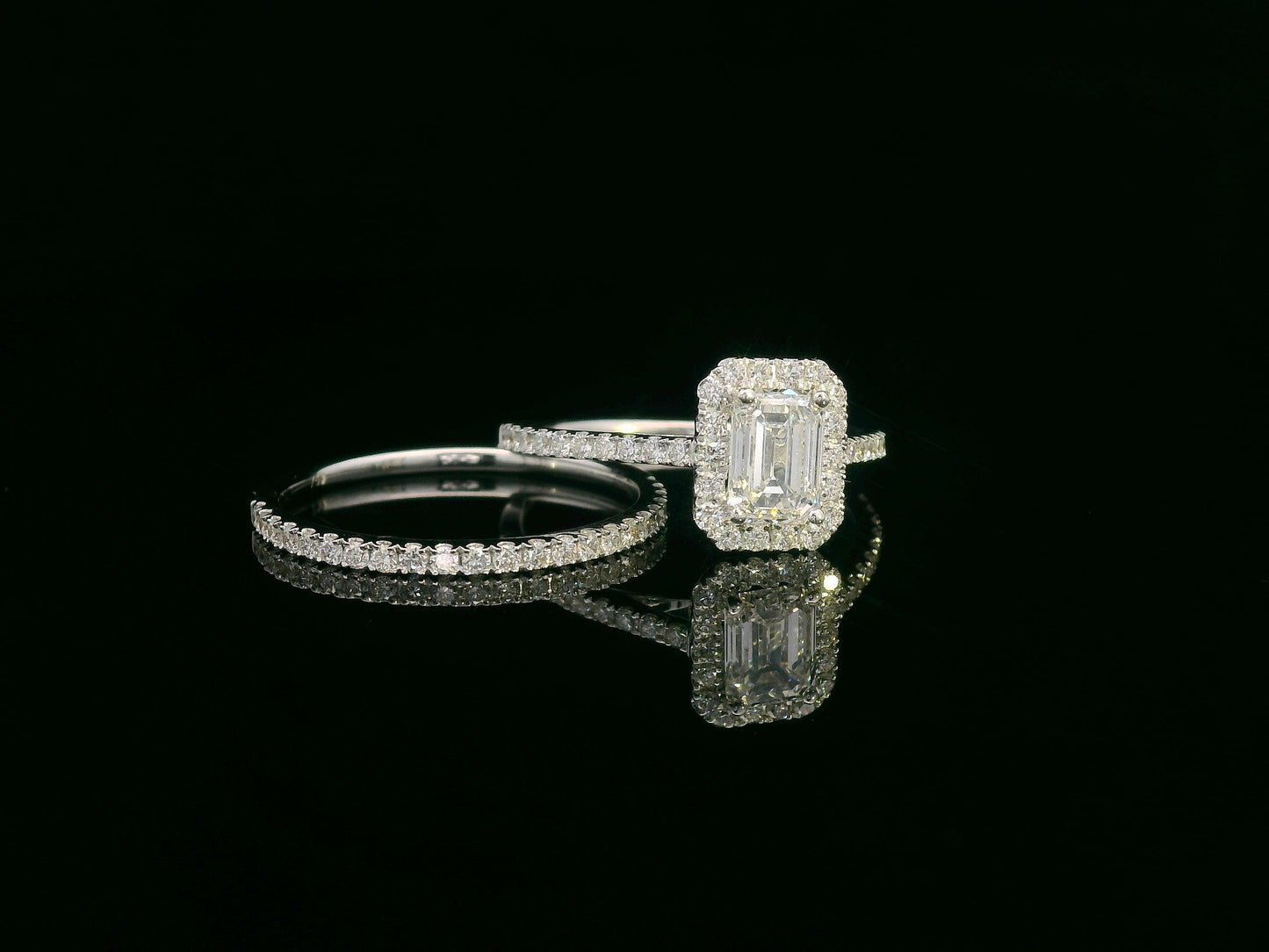 18K white gold bridal set with emerald-cut 1.00ct diamond, halo engagement ring, and half-eternity diamond band