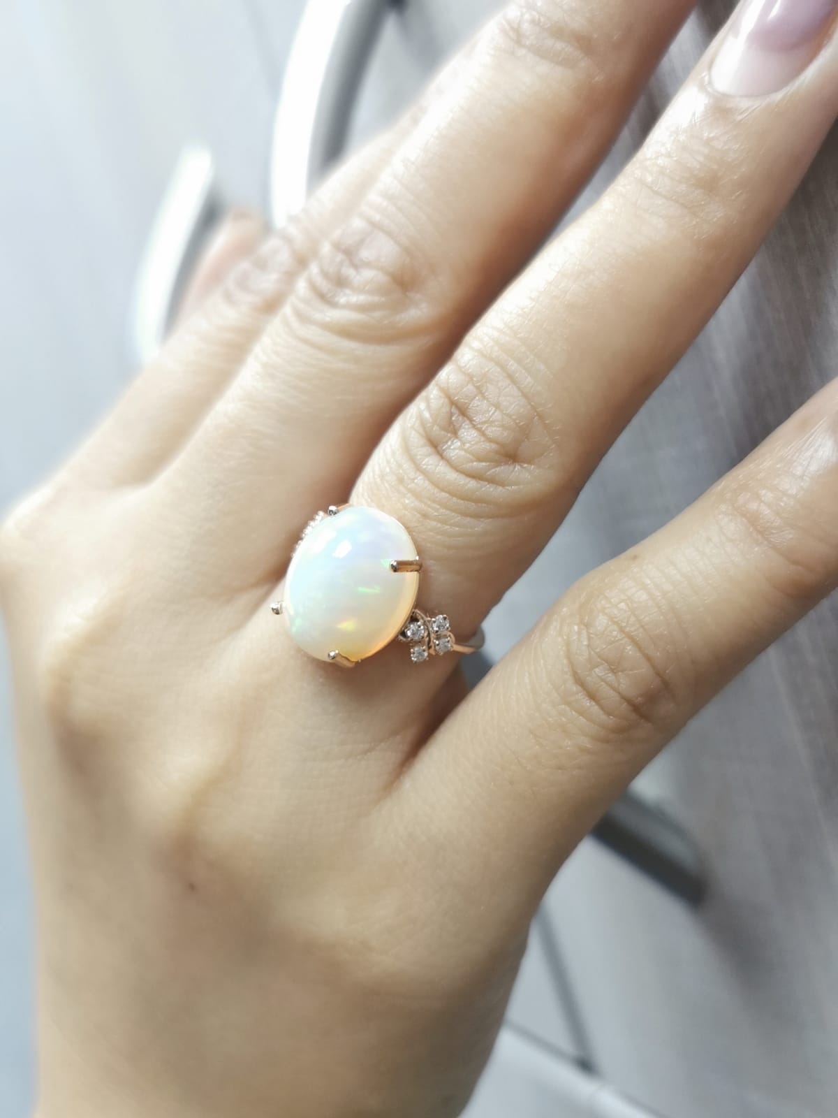 18K rose gold ring with 5.44ct oval opal cabochon and artistic diamond-accented side design