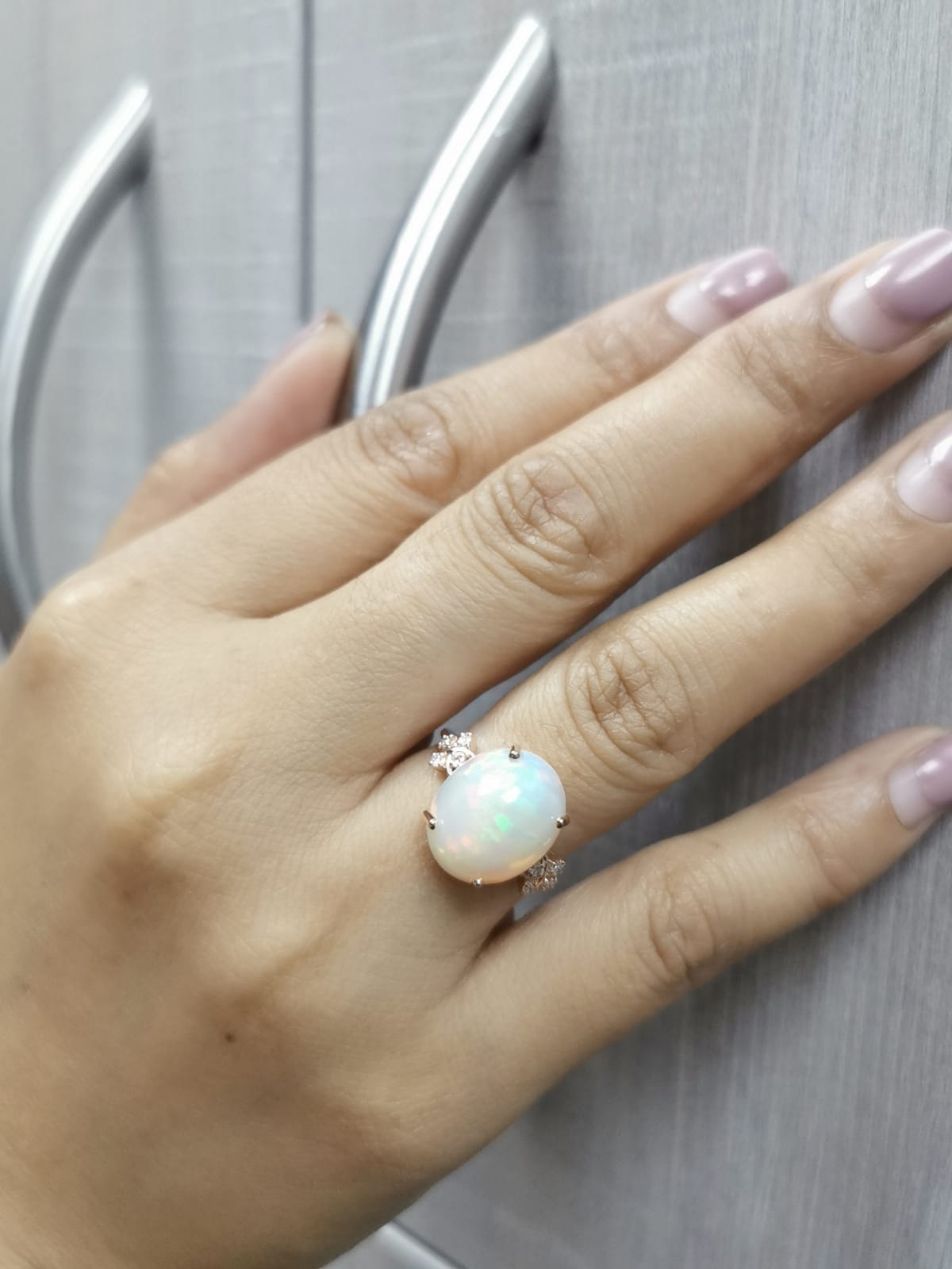 18K rose gold ring with 5.44ct oval opal cabochon and artistic diamond-accented side design