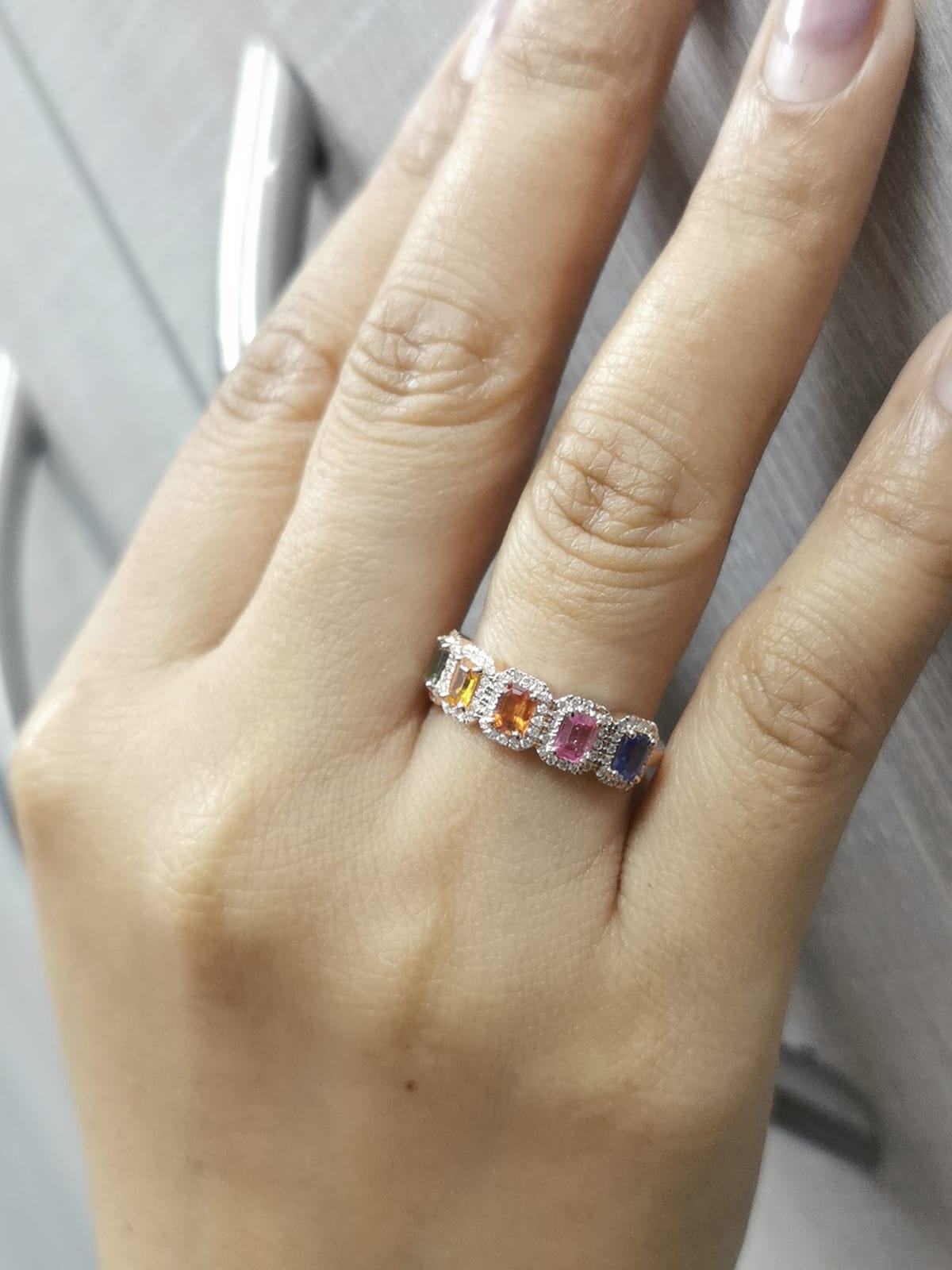 18K rose gold ring with emerald-cut multi-color sapphires and diamond halos