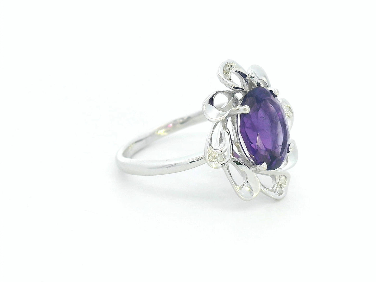 white gold ring with a purple gemstone on a white background