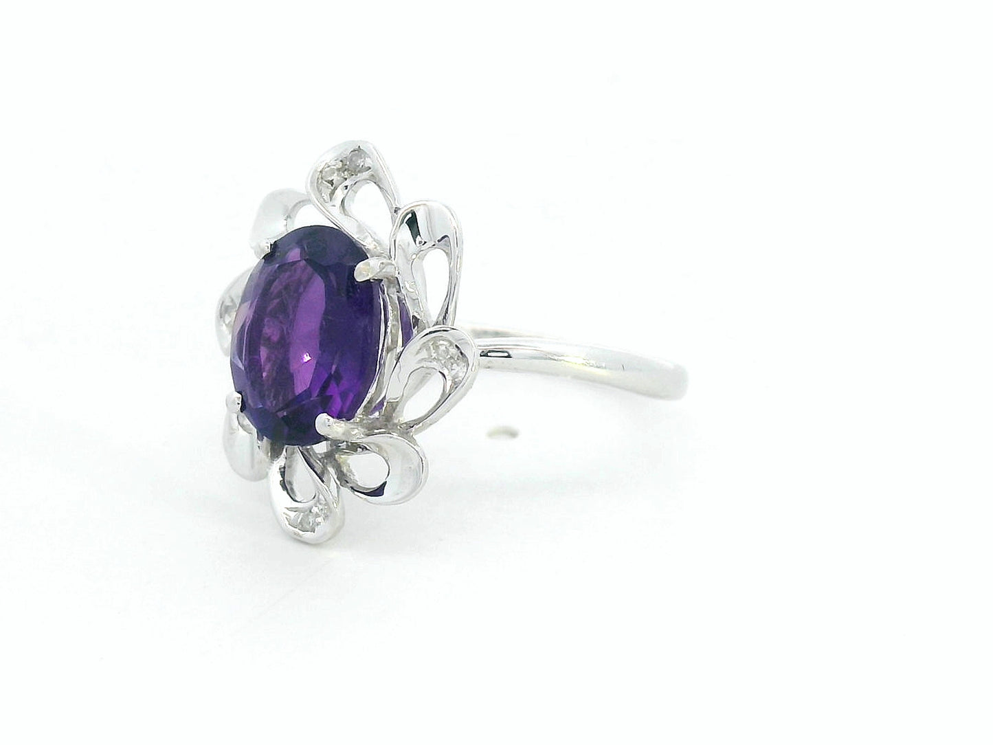 white gold ring with a purple gemstone on a white background
