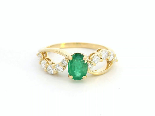 18K yellow gold ring with oval emerald and diamond split shank design