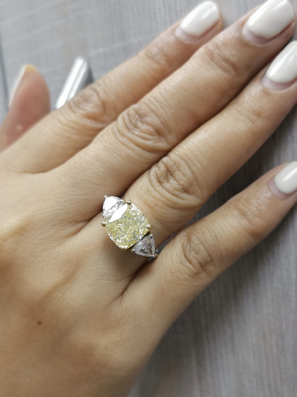 Diamond ring on a hand with a neutral background