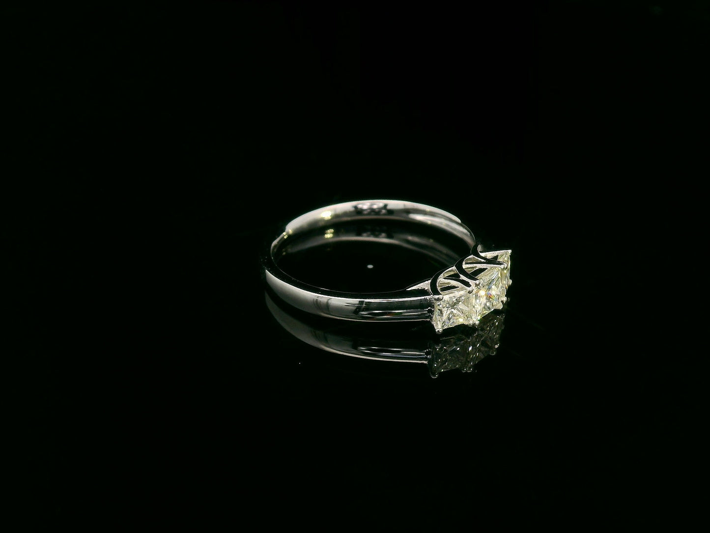 18k white gold trilogy ring with three princess-cut diamonds, total 0.66 ct, modern classic design.