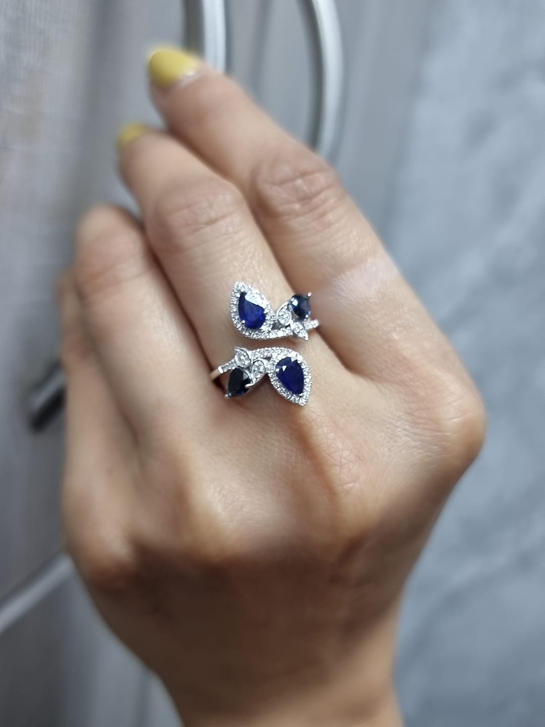 Ring on finger showcasing elegant white gold band with sapphires and diamonds