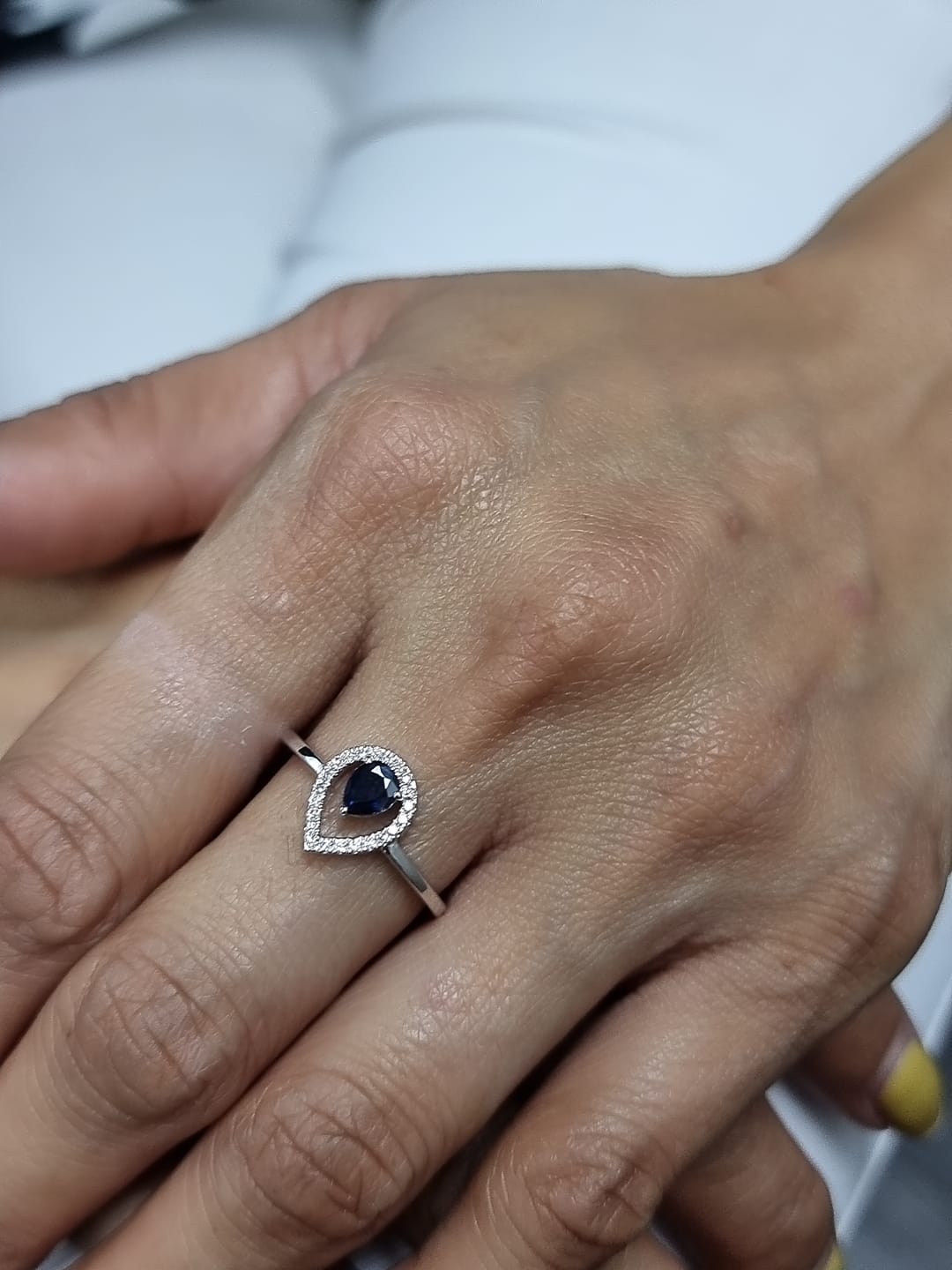 18k white gold ring with 0.41ct pear-cut blue sapphire and 0.11ct open diamond halo – certificate included