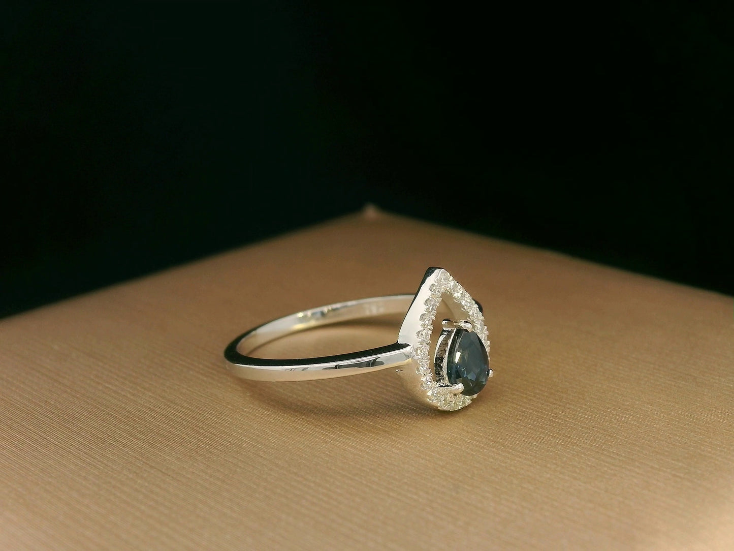 18k white gold ring with 0.41ct pear-cut blue sapphire and 0.11ct open diamond halo – certificate included