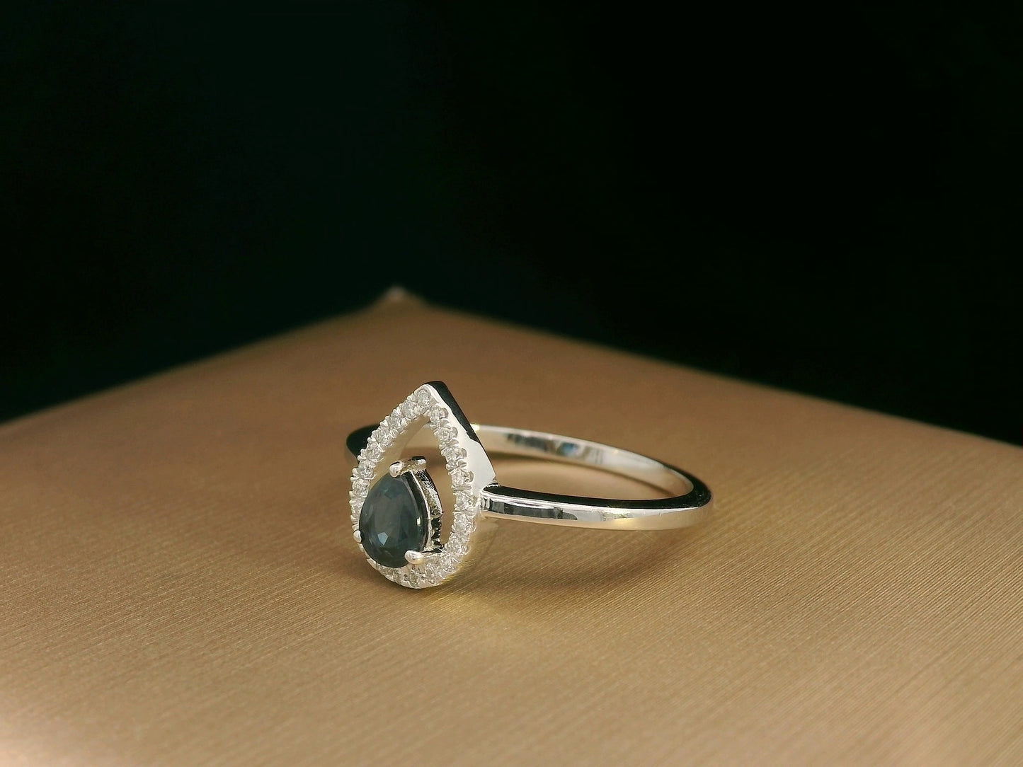 18k white gold ring with 0.41ct pear-cut blue sapphire and 0.11ct open diamond halo – certificate included