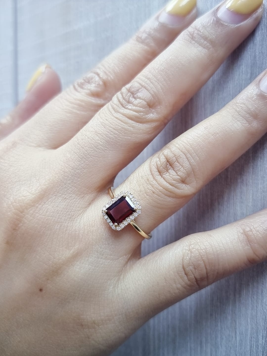 18k yellow gold ring featuring 1.67ct emerald-cut garnet with 0.14ct diamond halo