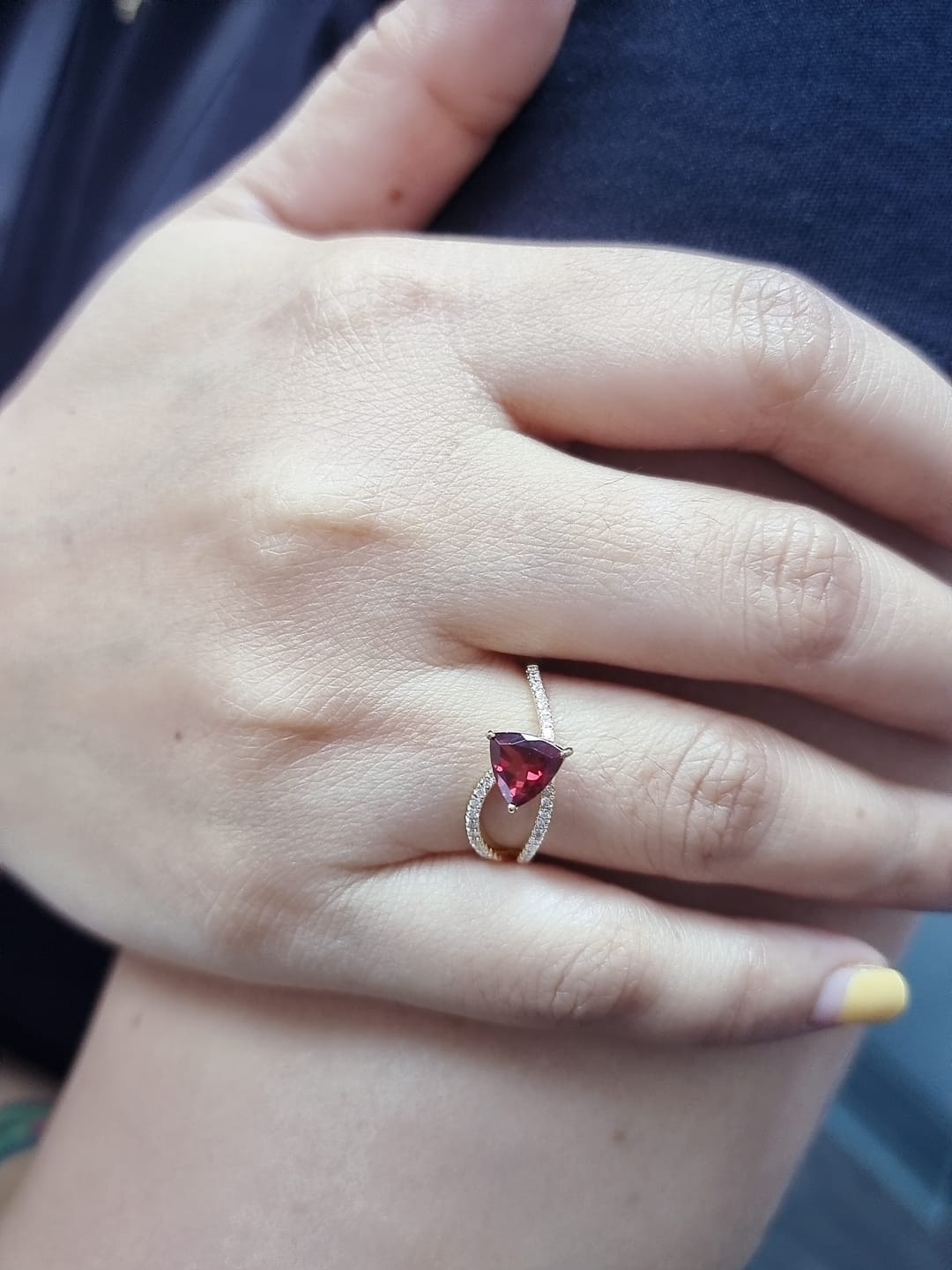 18k yellow gold ring with trillion-cut garnet and diamond crossover band. Comes with a certificate of authenticity