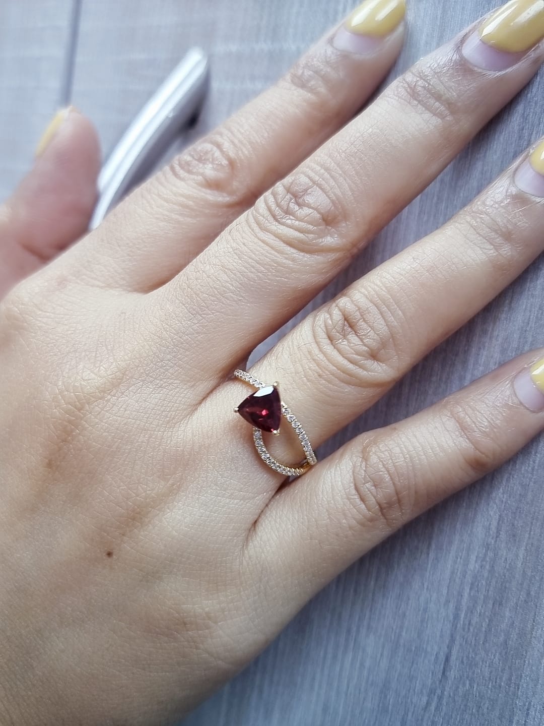 18k yellow gold ring with trillion-cut garnet and diamond crossover band. Comes with a certificate of authenticity