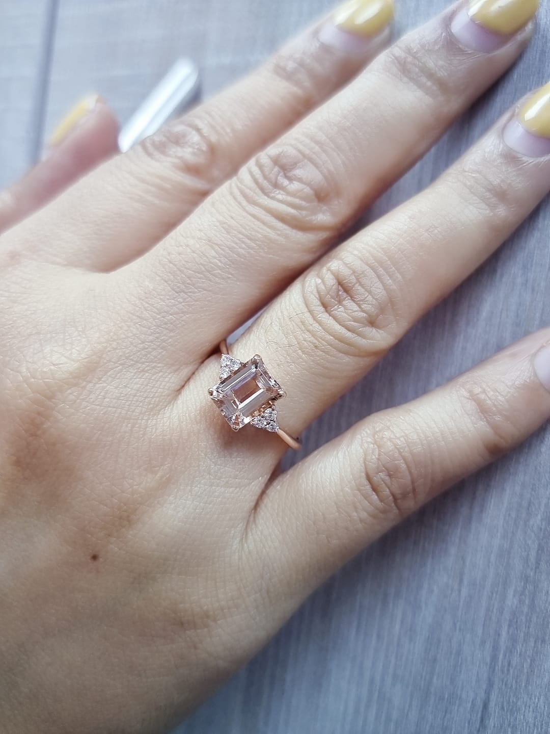 18K rose gold ring featuring a 1.80ct emerald-cut Morganite with diamond clusters on each side.