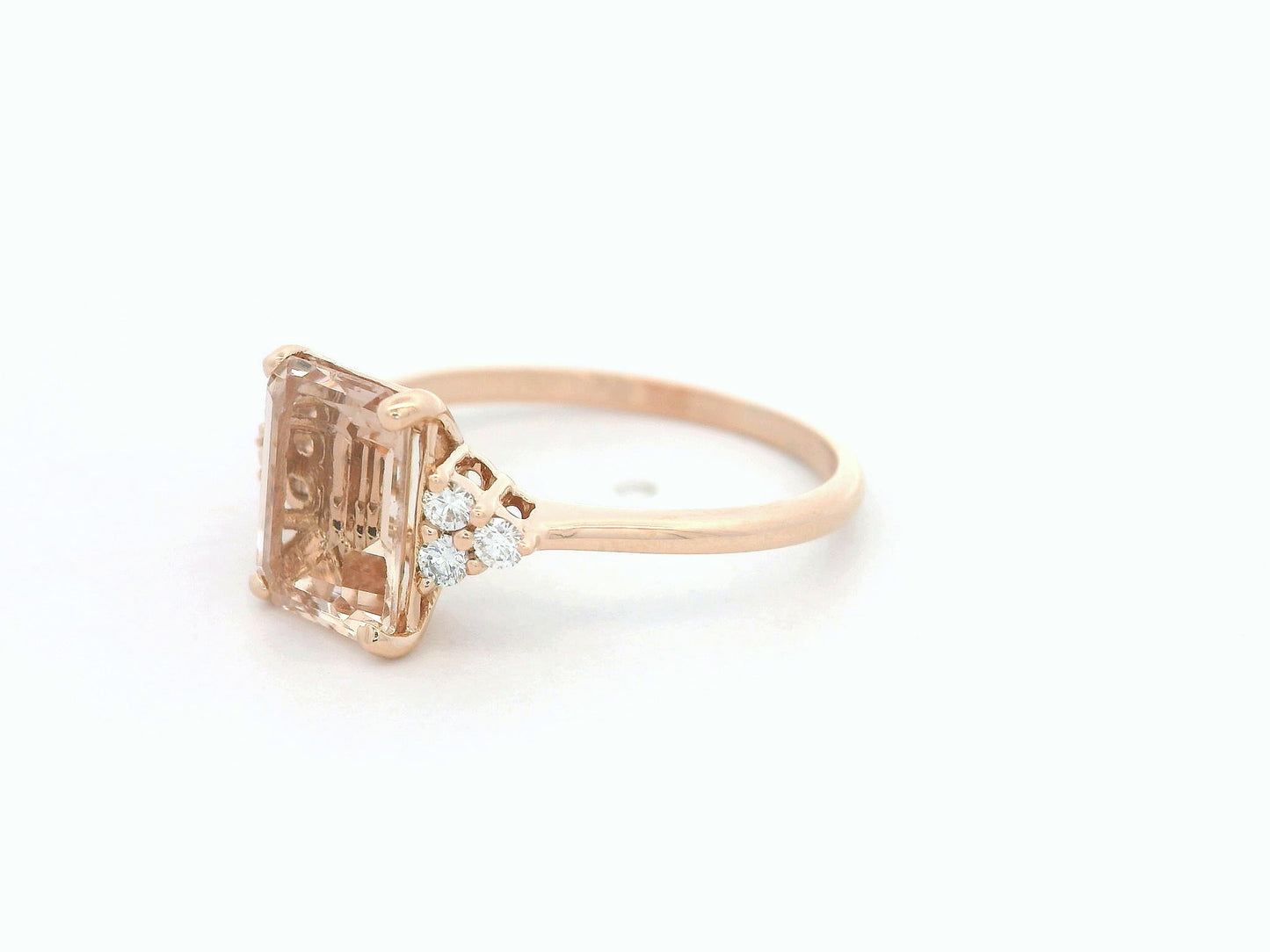 18K rose gold ring featuring a 1.80ct emerald-cut Morganite with diamond clusters on each side.