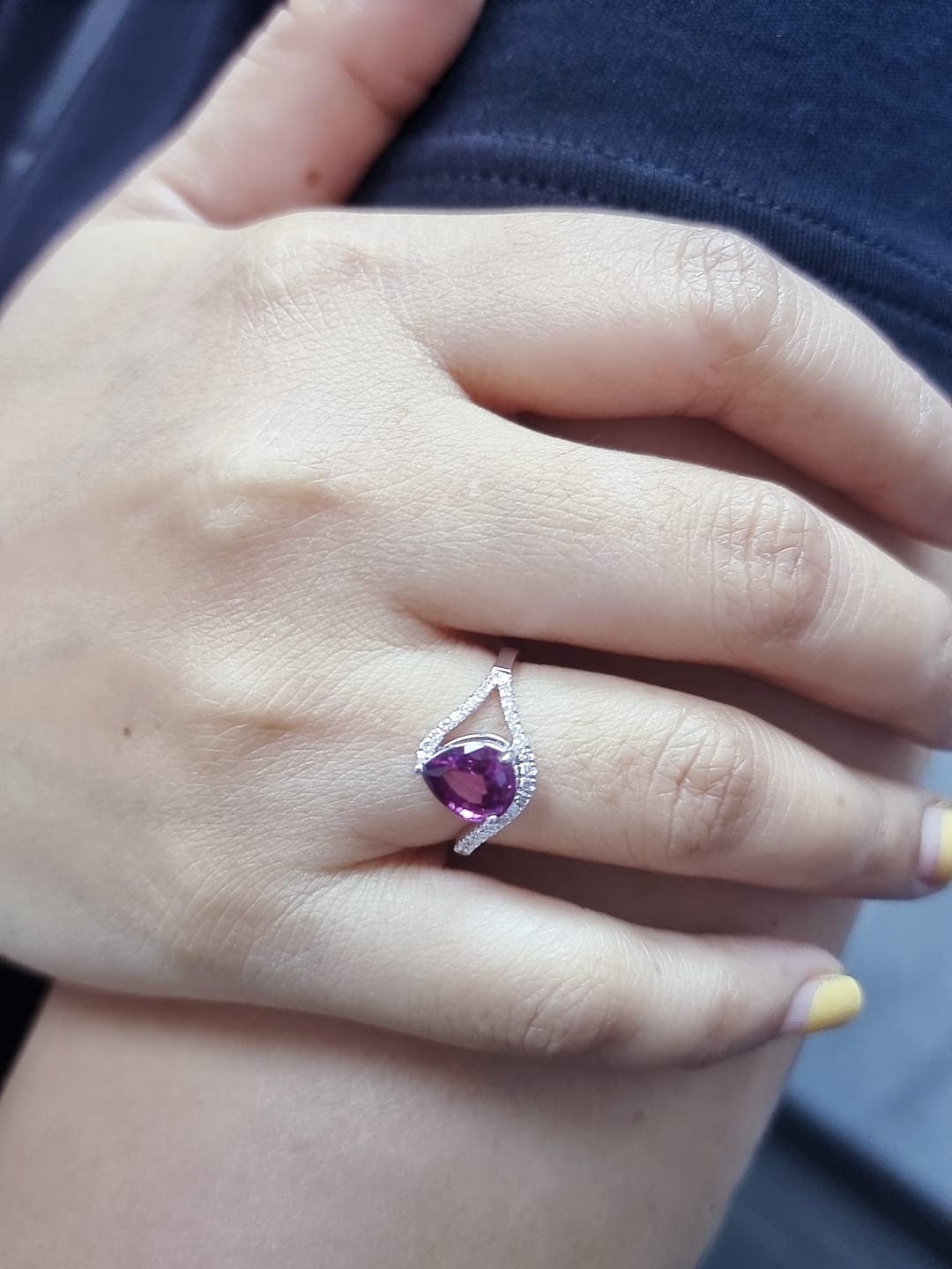 18K white gold rhodolite garnet and diamond wave ring featuring a 1.97ct pear-cut garnet framed by 0.23ct pavé diamonds in an elegant wave design.