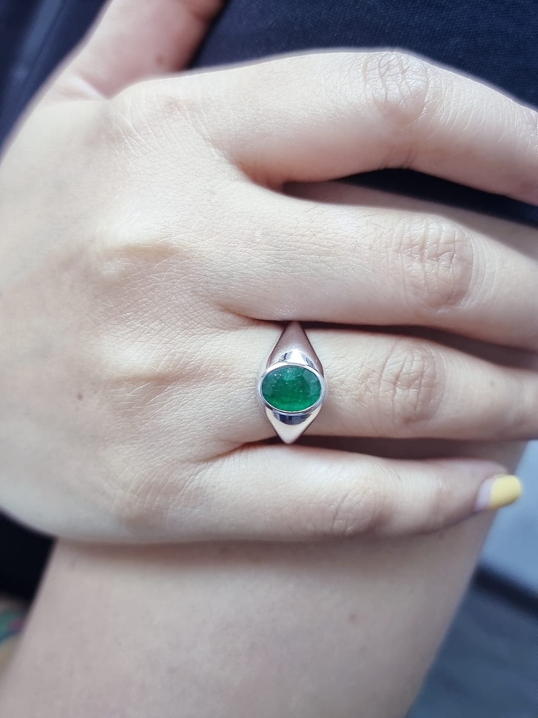 18K white gold men’s signet ring featuring a 1.80ct oval-cut emerald in a sleek bezel setting with a solid tapered band.