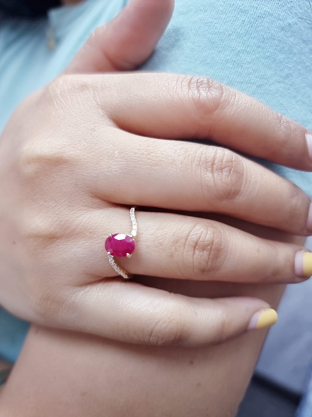 18K yellow gold ruby and diamond wave ring featuring an oval 1.56ct ruby and 0.13ct round diamonds in a flowing wave design.