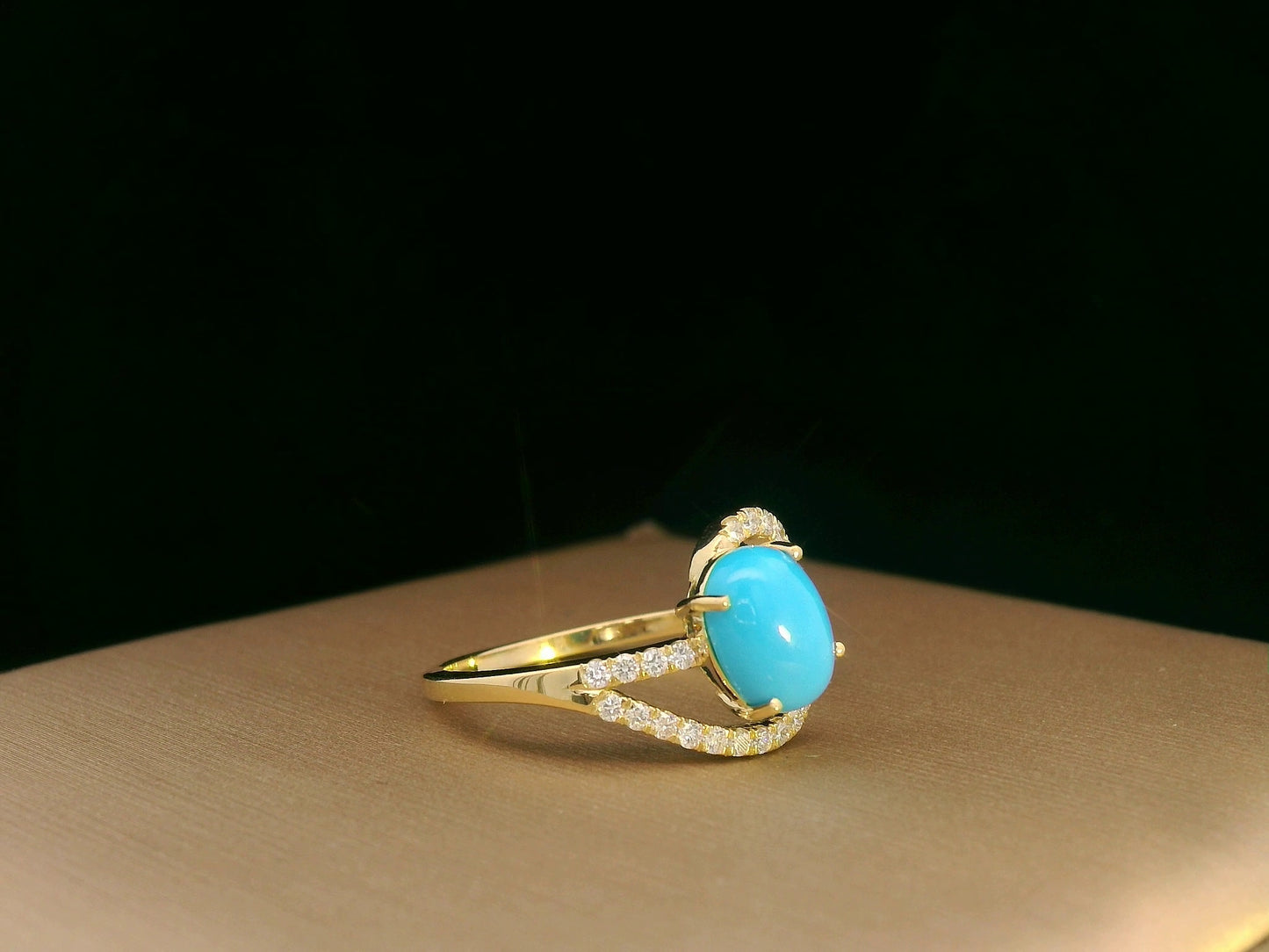 18K yellow gold ring featuring a 1.21ct oval turquoise center with 0.24ct diamonds in an asymmetrical halo and diamond-lined shank.