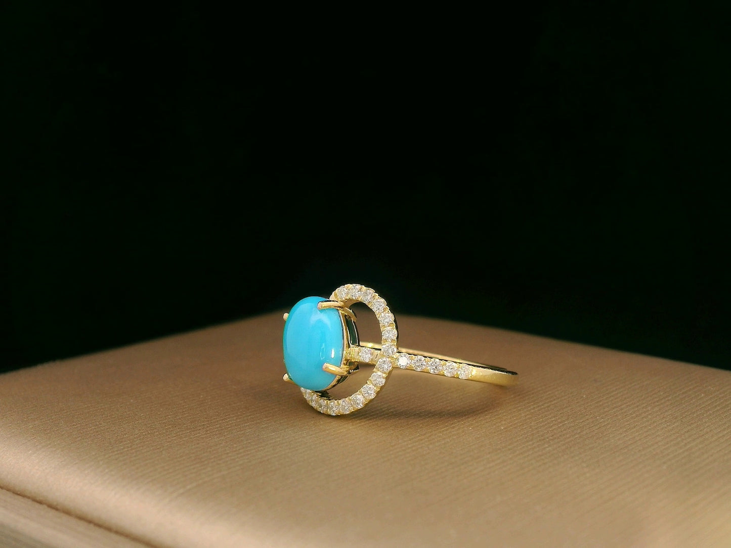 18K yellow gold ring featuring a 1.21ct oval turquoise center with 0.24ct diamonds in an asymmetrical halo and diamond-lined shank.