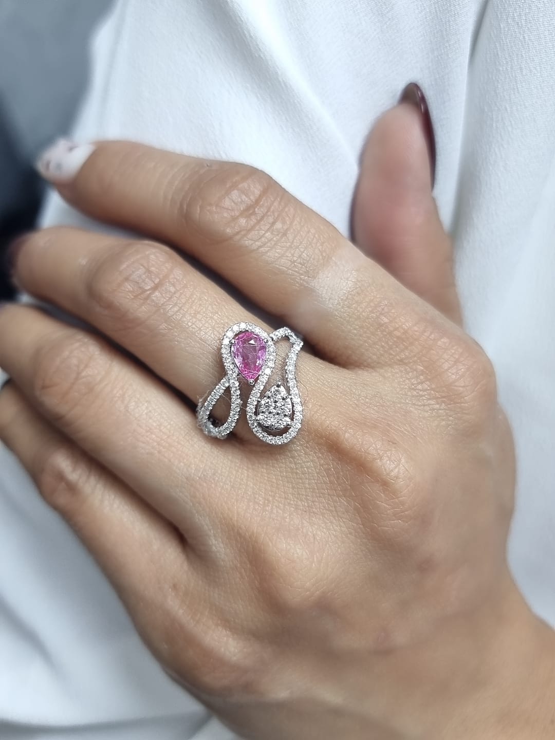 18k white gold ring with 0.74ct pear-shaped pink sapphire and 0.59ct diamonds in a sculptural double-drop design.