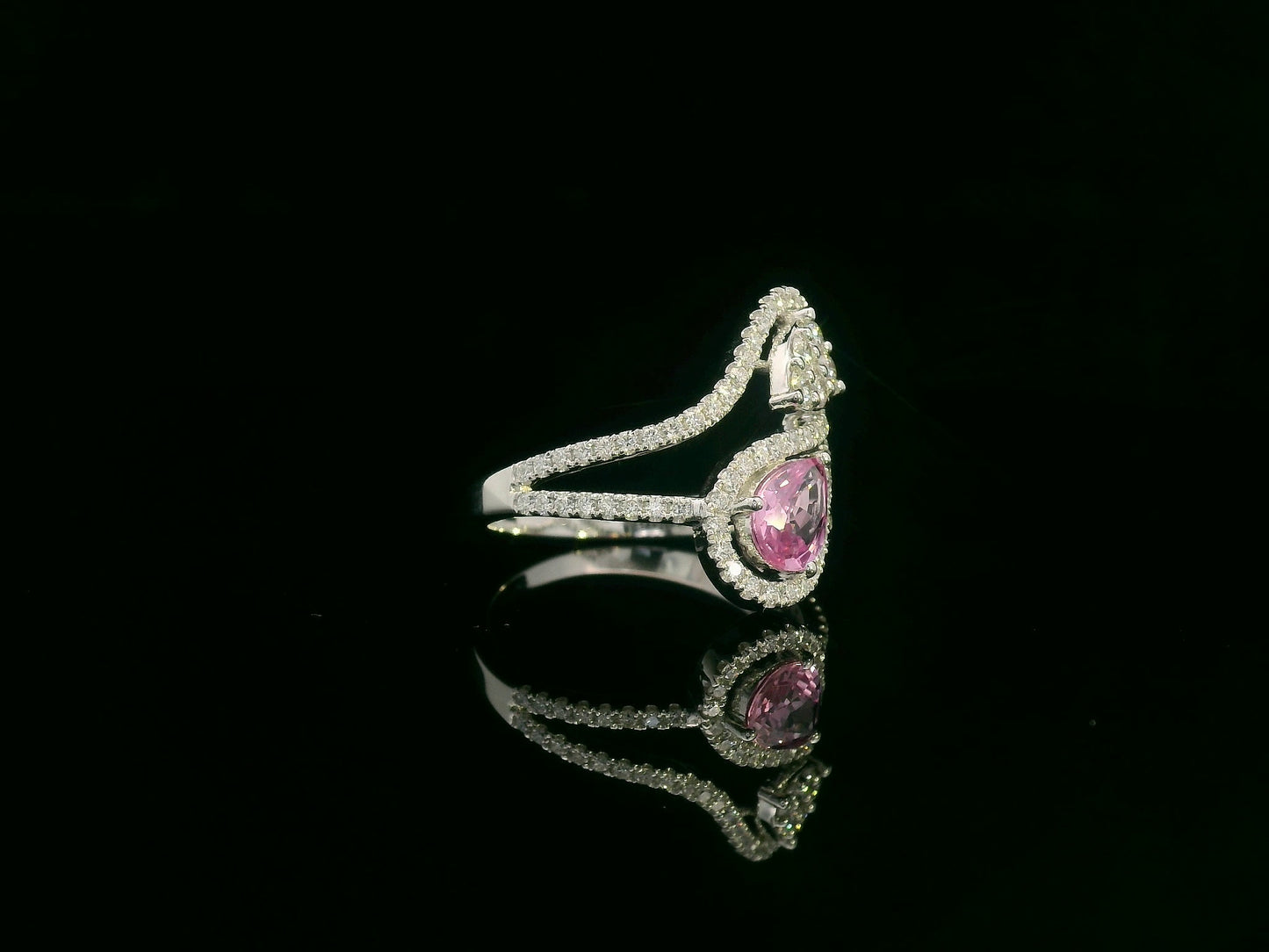 18k white gold ring with 0.74ct pear-shaped pink sapphire and 0.59ct diamonds in a sculptural double-drop design.