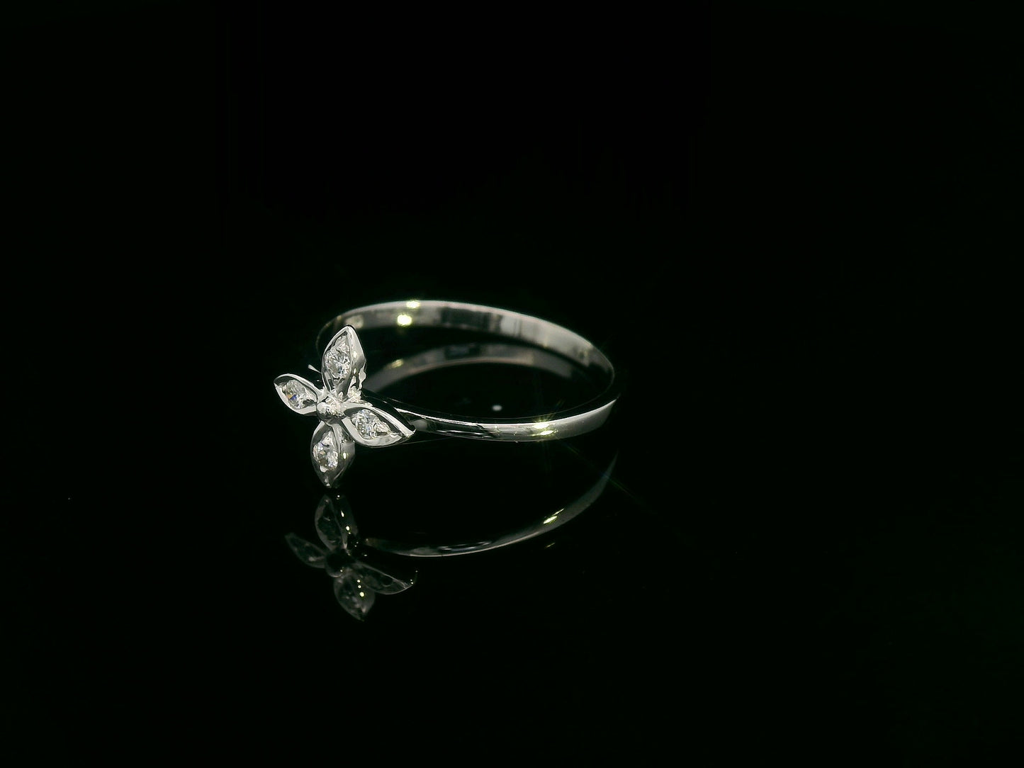 18k gold ring featuring a floral motif with four marquise-shaped diamonds forming a cross, set on a slim minimalist band for modern elegance