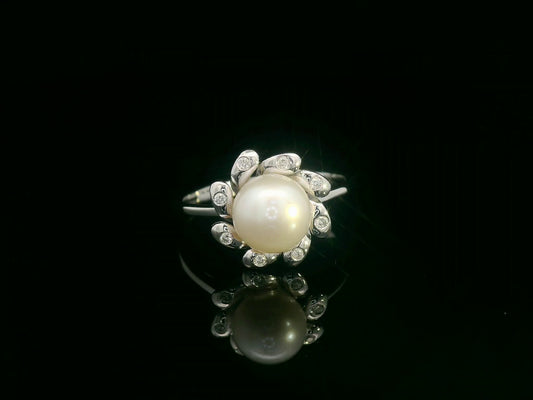 18K white gold ring featuring a luminous freshwater pearl at the center, surrounded by a floral-inspired setting with 0.06ct round diamonds.