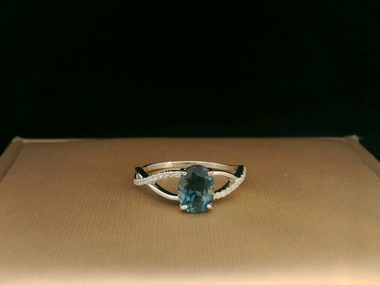 18K white gold ring featuring a 1.58ct London Blue Topaz with 0.11ct diamonds set along a twisted split-shank band.