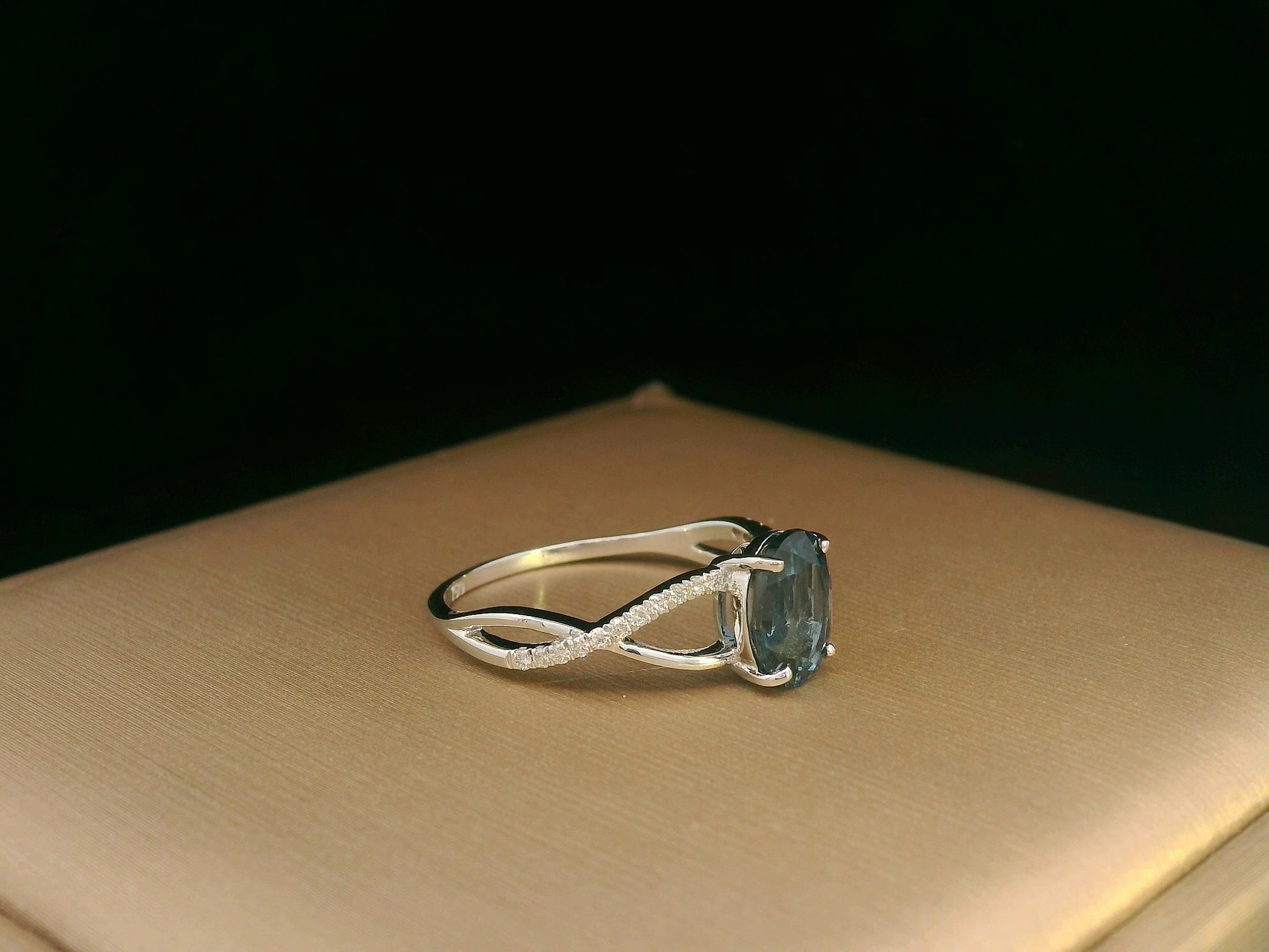 18K white gold ring featuring a 1.58ct London Blue Topaz with 0.11ct diamonds set along a twisted split-shank band.