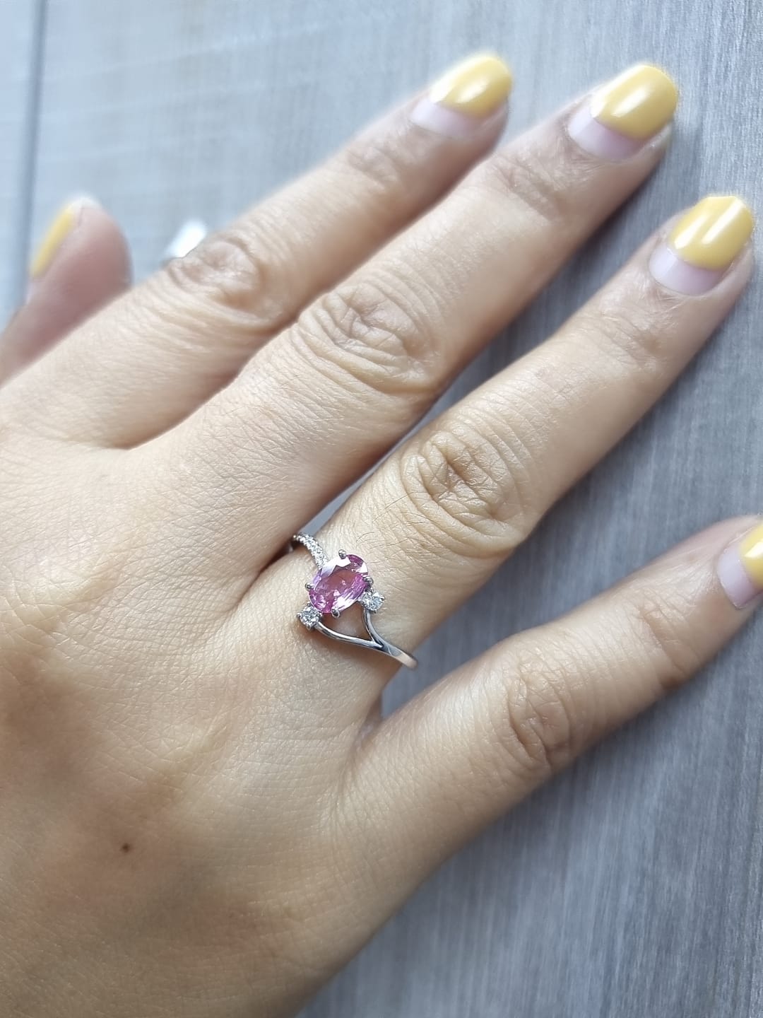 18K white gold ring featuring a 0.75ct oval Pink Sapphire with 0.12ct diamonds on an asymmetric split band.