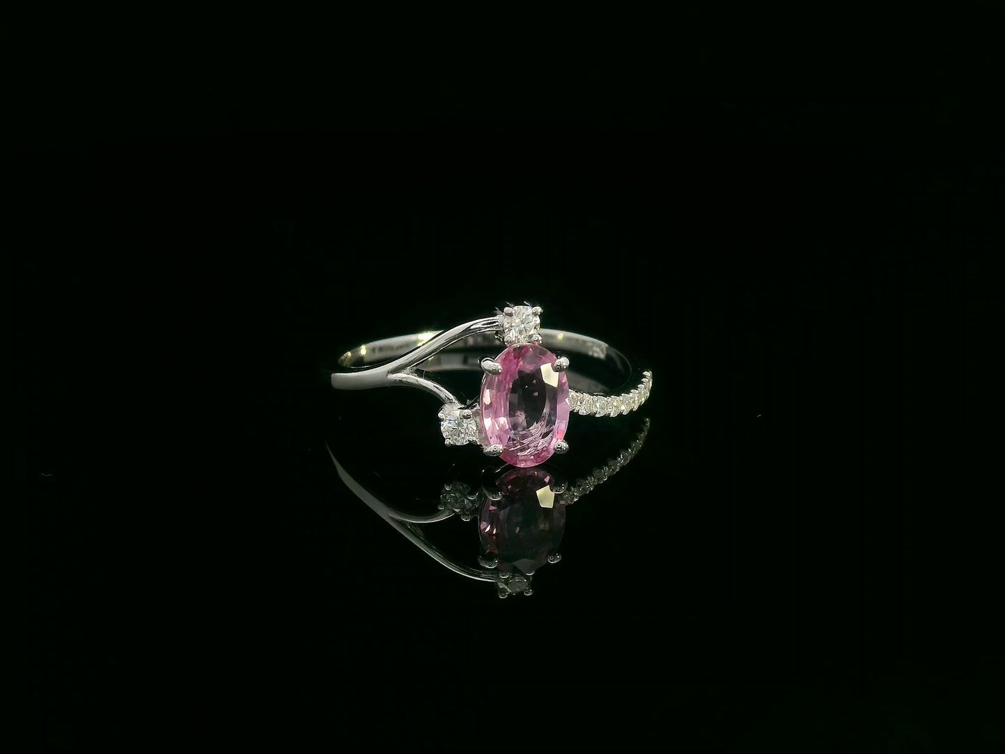 18K white gold ring featuring a 0.75ct oval Pink Sapphire with 0.12ct diamonds on an asymmetric split band.