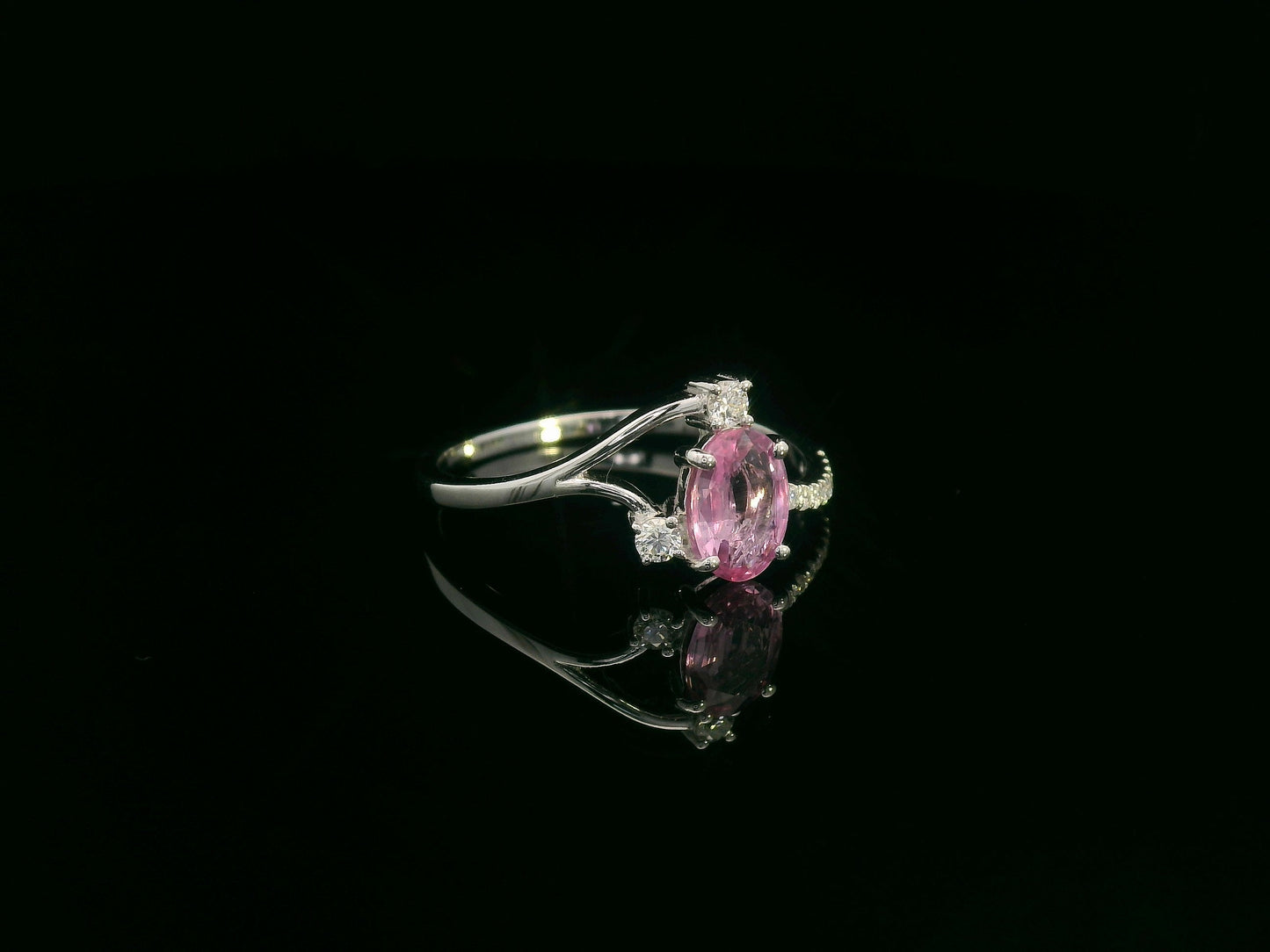 18K white gold ring featuring a 0.75ct oval Pink Sapphire with 0.12ct diamonds on an asymmetric split band.