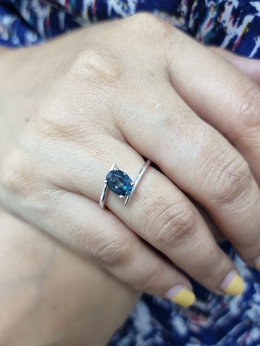18K white gold bypass ring featuring a 1.49ct oval London Blue Topaz prong-set between gracefully crossing bands.