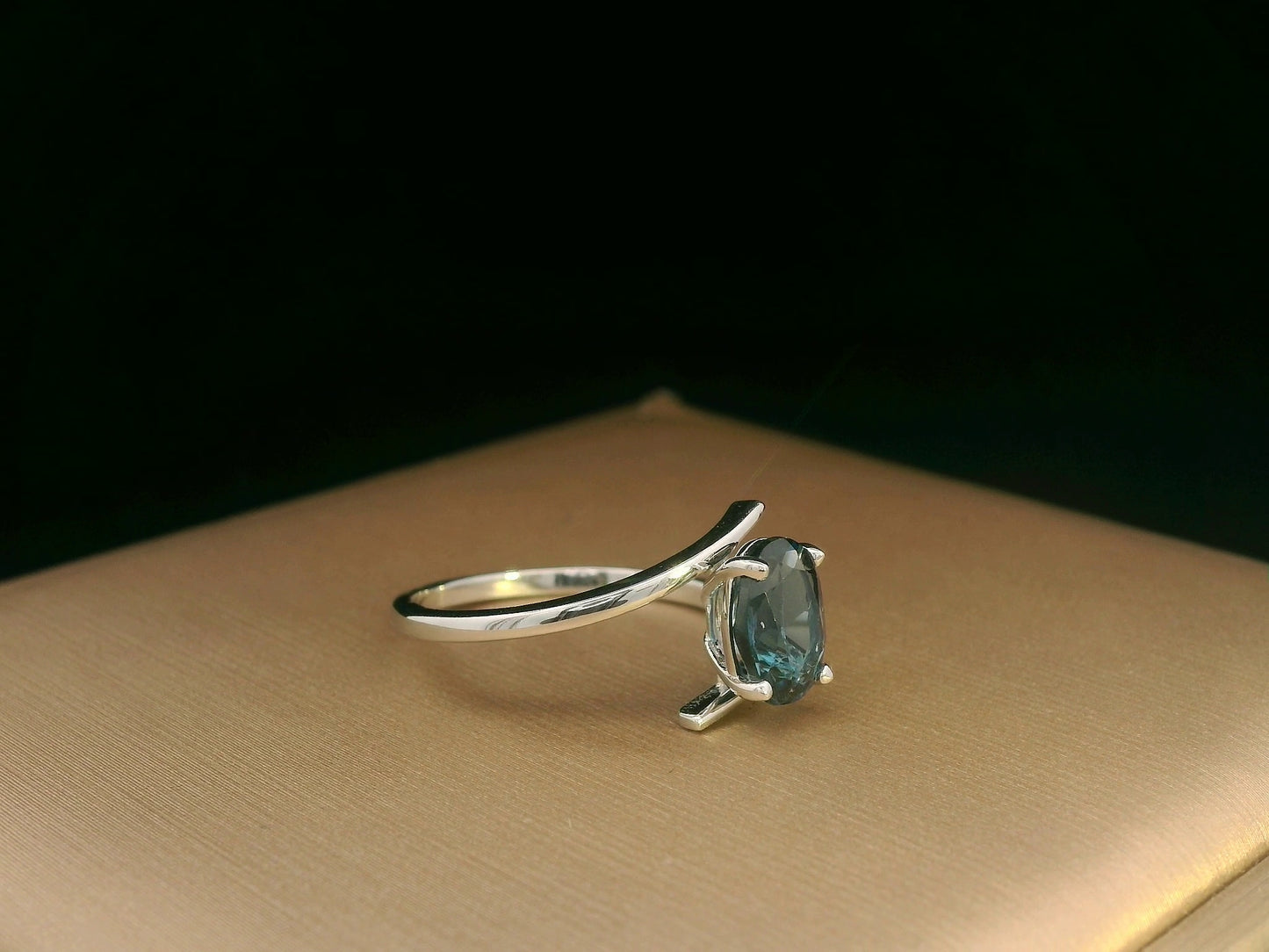 18K white gold bypass ring featuring a 1.49ct oval London Blue Topaz prong-set between gracefully crossing bands.