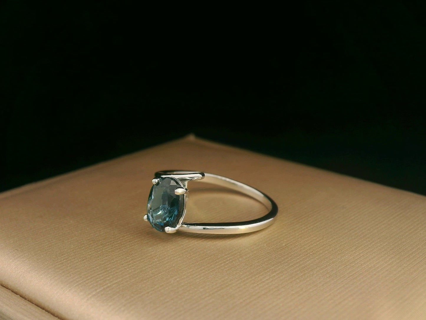 18K white gold bypass ring featuring a 1.49ct oval London Blue Topaz prong-set between gracefully crossing bands.