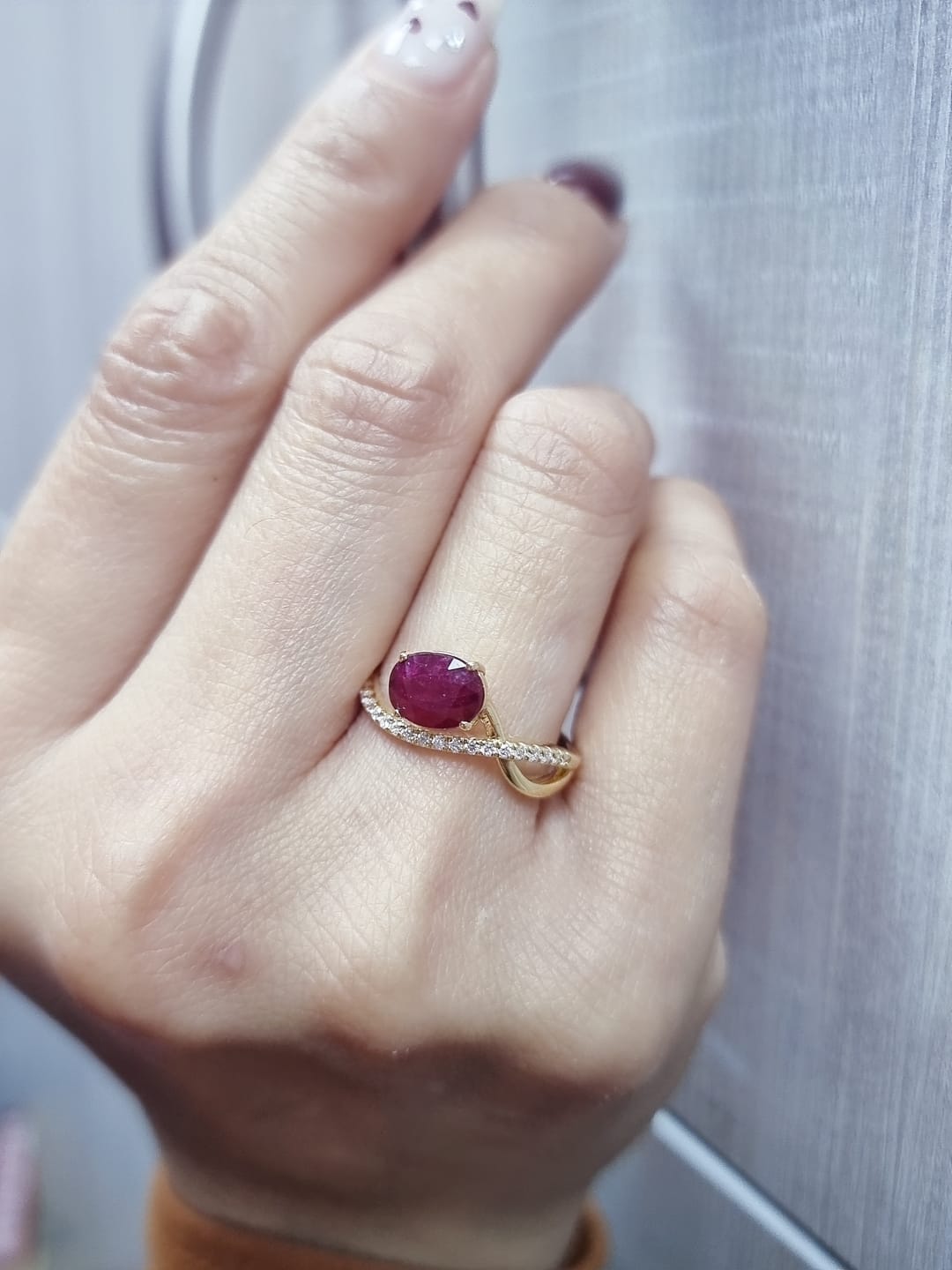 18K yellow gold oval ruby bypass ring with round diamond accents, modern luxury design