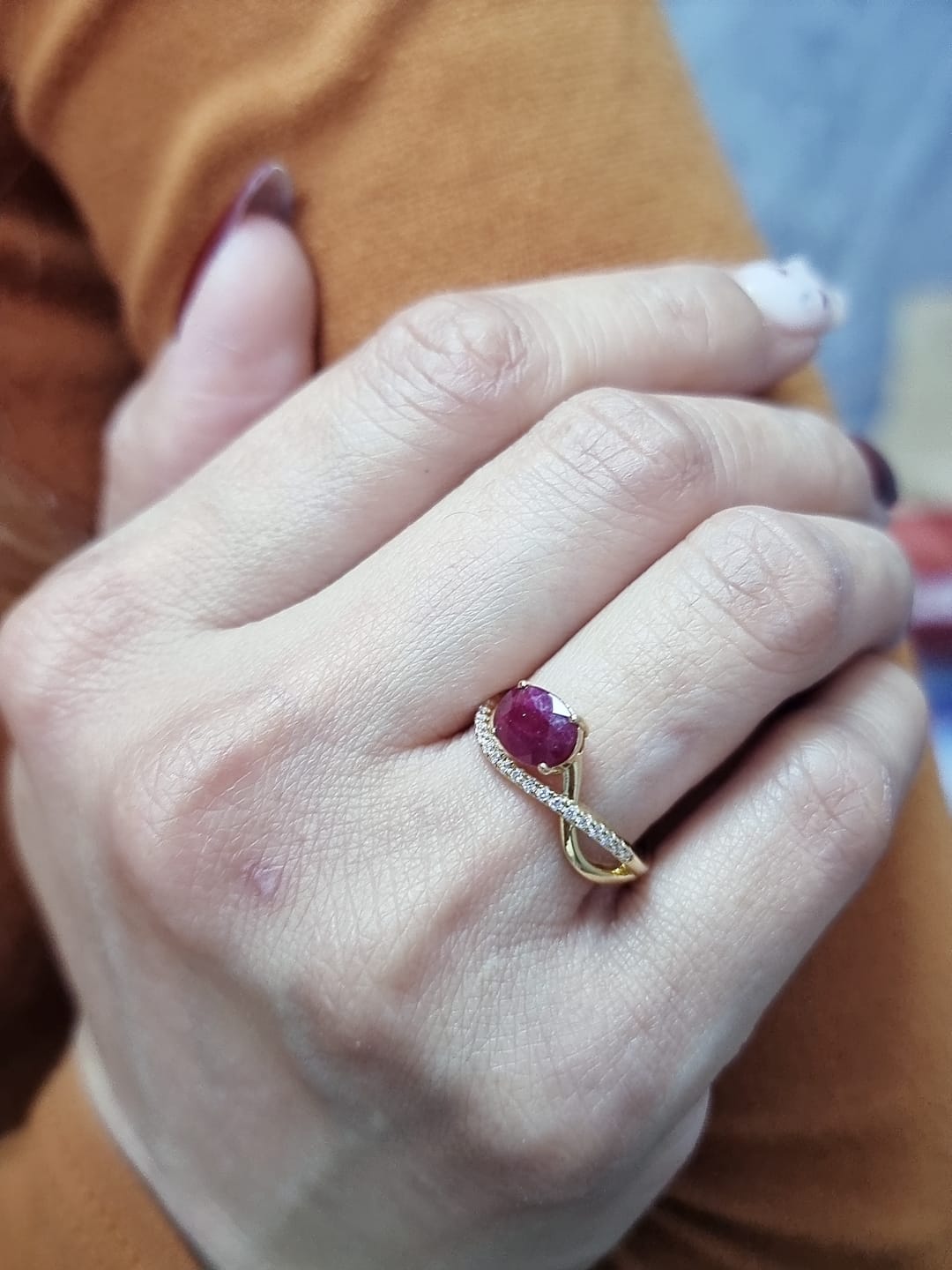 18K yellow gold oval ruby bypass ring with round diamond accents, modern luxury design