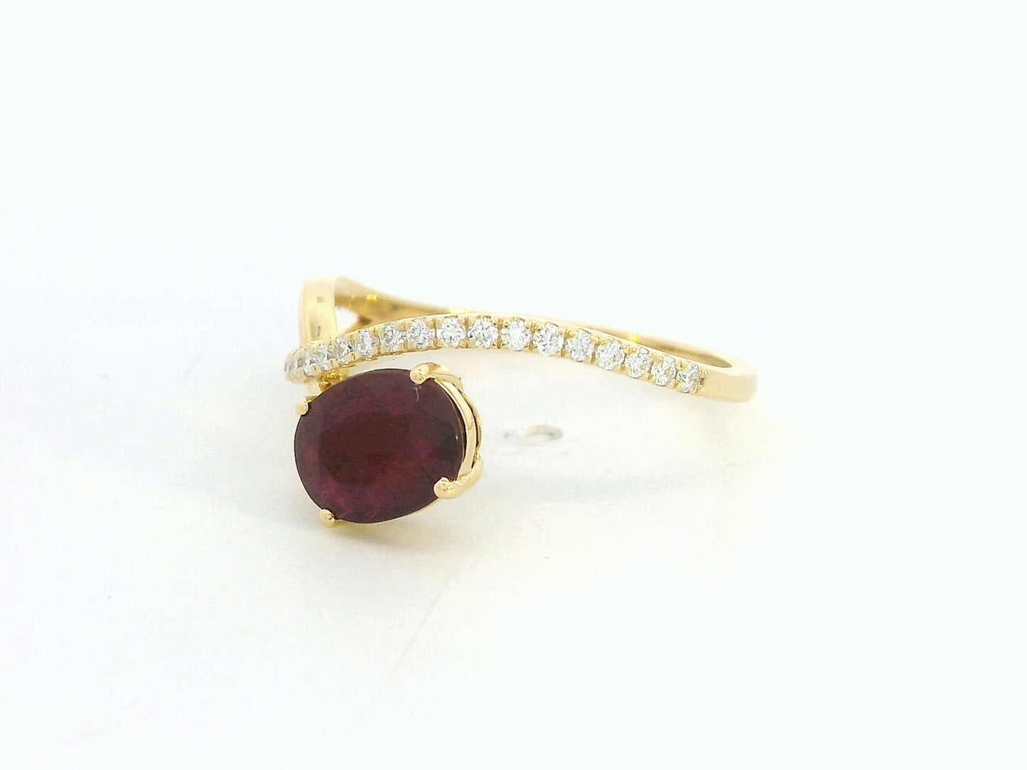 18K yellow gold oval ruby bypass ring with round diamond accents, modern luxury design