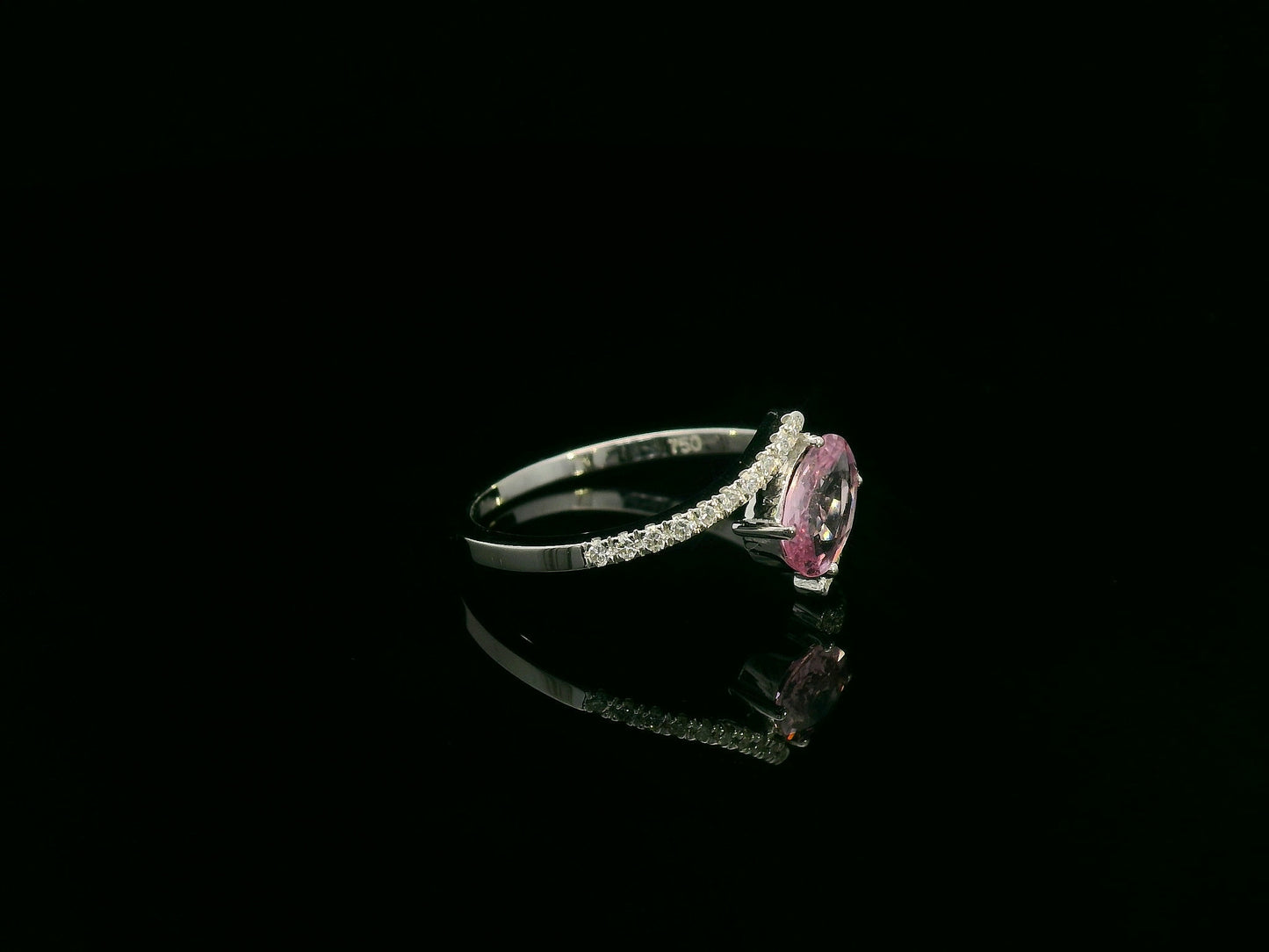 18K white gold bypass ring featuring an oval pink sapphire and pavé-set diamonds in a contemporary open design.