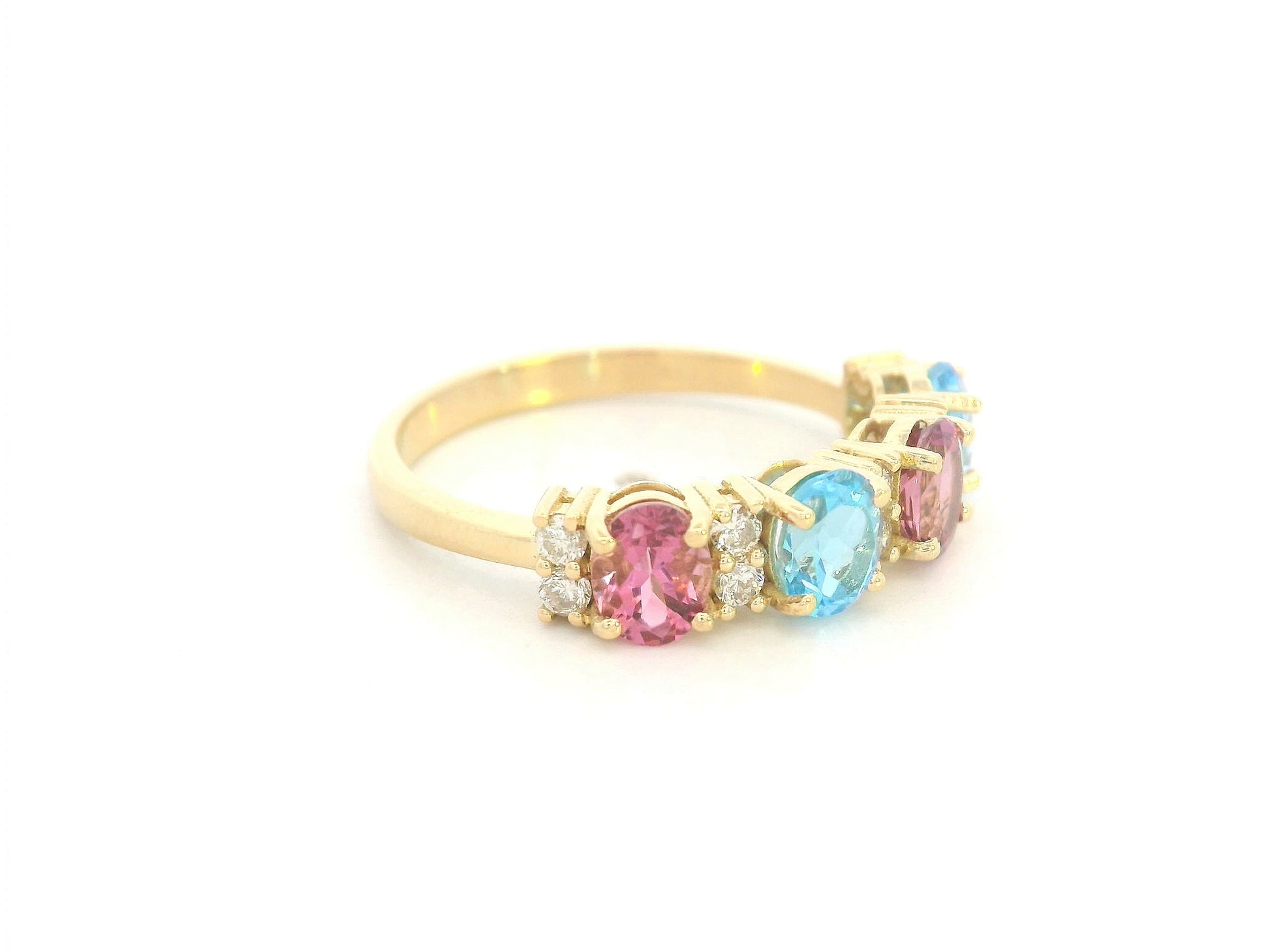18K yellow gold band with alternating oval pink and blue sapphires and round diamond accents