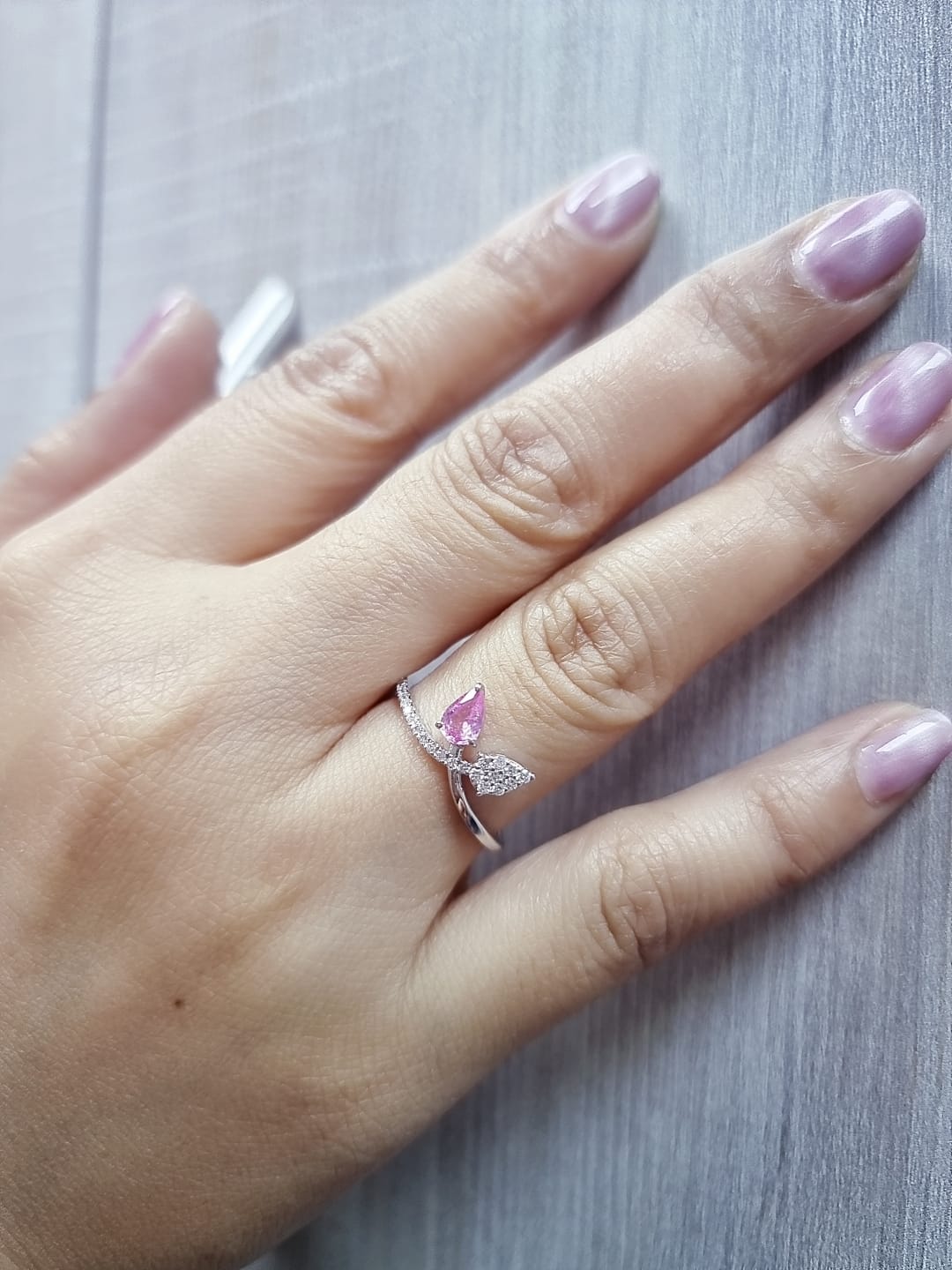 18K white gold bypass ring featuring 0.37ct pear pink sapphire and 0.15ct diamonds in a modern pear motif design.