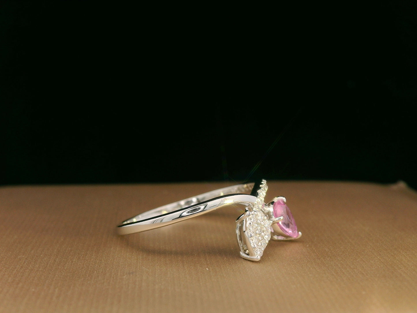 18K white gold bypass ring featuring 0.37ct pear pink sapphire and 0.15ct diamonds in a modern pear motif design.