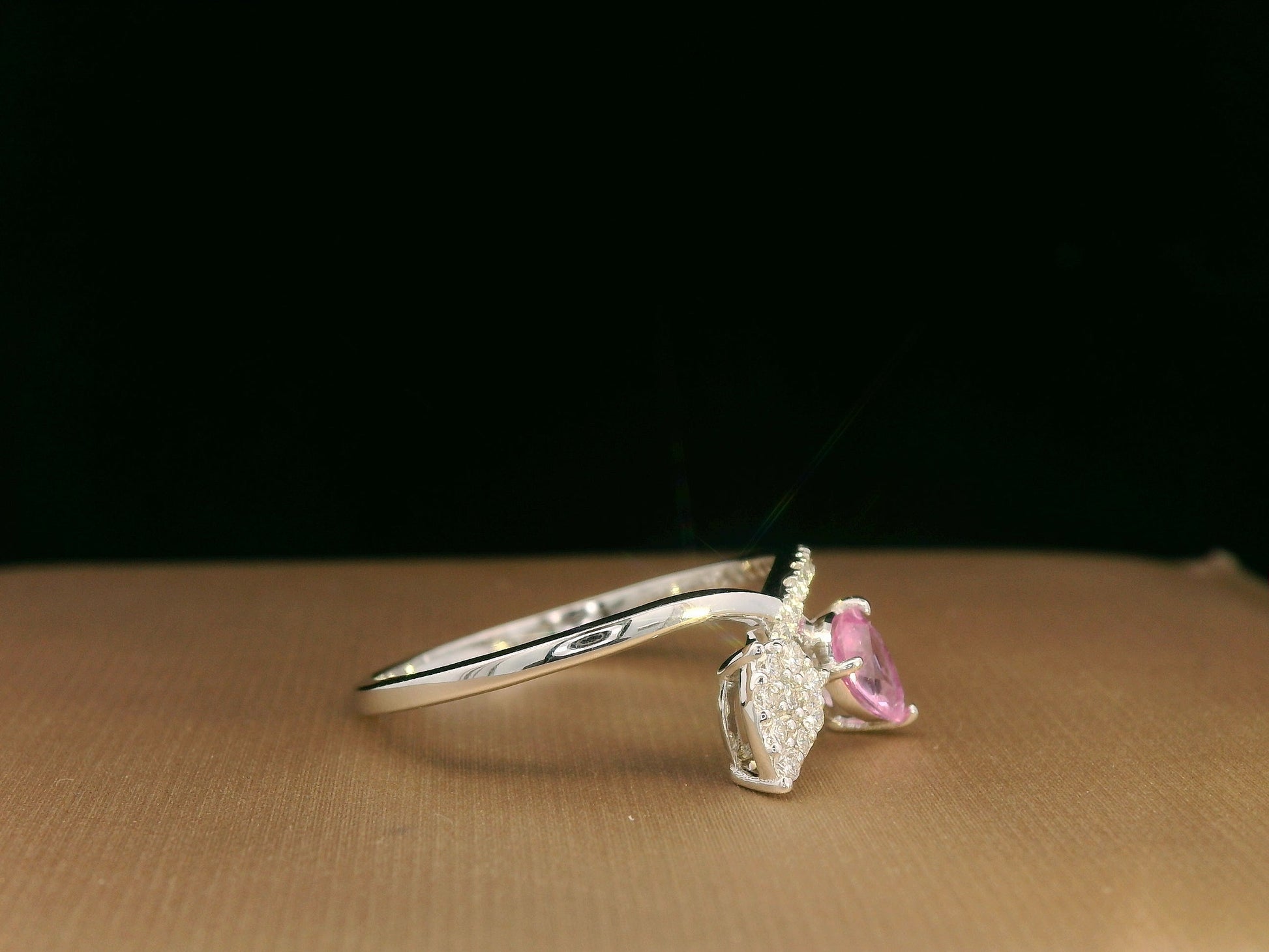 18K white gold bypass ring featuring 0.37ct pear pink sapphire and 0.15ct diamonds in a modern pear motif design.